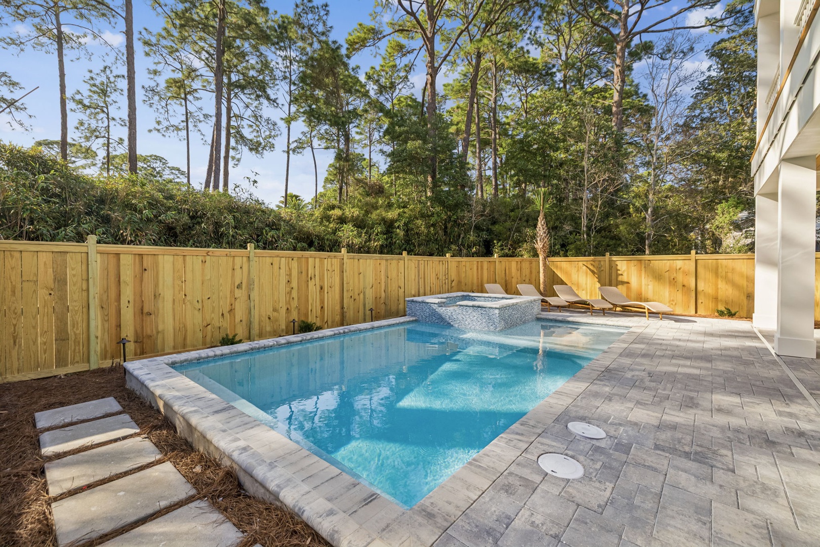 Dive into your private oasis with crystal-clear waters and hot tub relaxation, surrounded by towering pines.