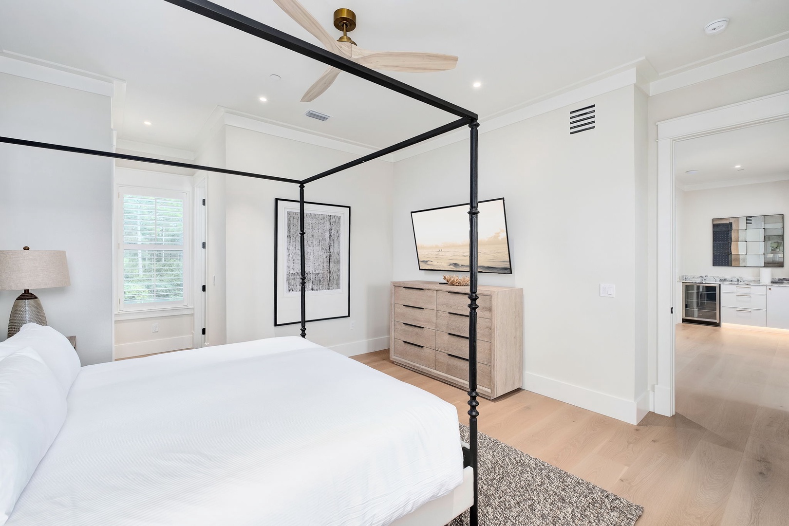 Step into your serene bedroom retreat with crisp white linens, a stylish canopy bed, and modern ceiling fan—your peaceful sanctuary awaits.
