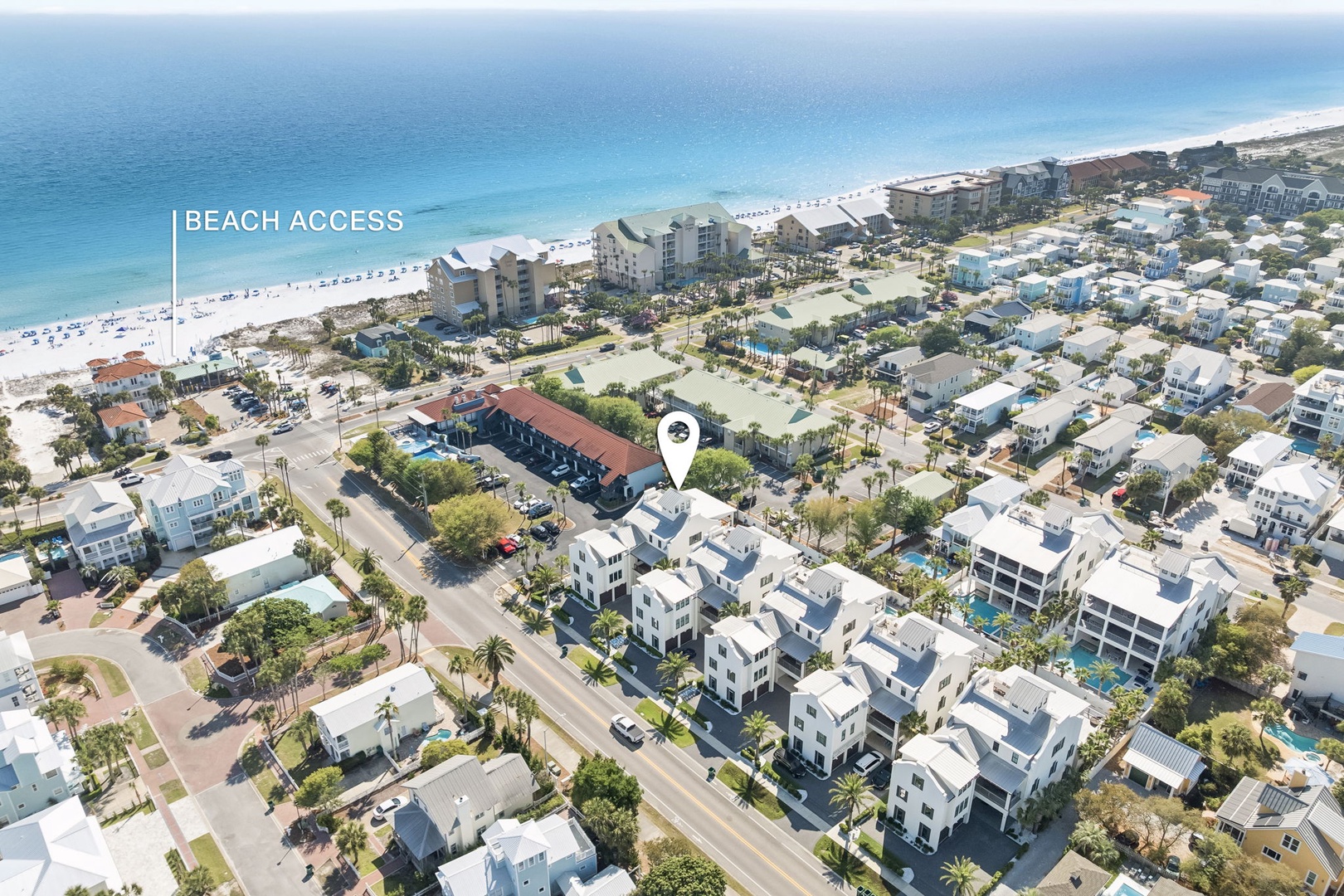 Aerial view of beachfront vacation rental community with pristine white sand beaches and turquoise waters just moments away.
