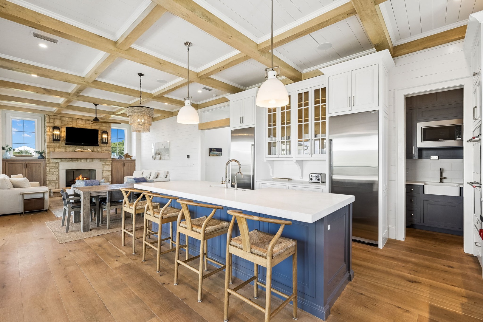 Gather around the spacious kitchen island with your loved ones, bathed in natural light from the vaulted wood-beam ceiling. The open layout connects cooking, dining, and cozy fireside moments seamlessly.