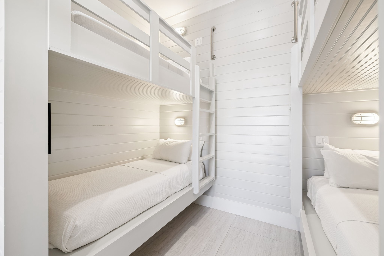 Your cozy bunk room features crisp white linens and reading lights, perfect for restful nights in this thoughtfully designed space.
