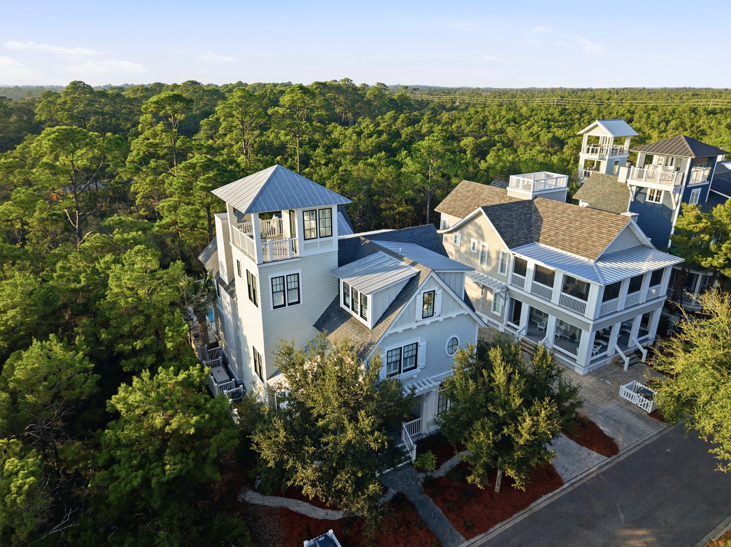 Aerial view of the vacation rental property nestled among lush greenery, with distinctive coastal architecture and ample natural surroundings providing a peaceful retreat setting.