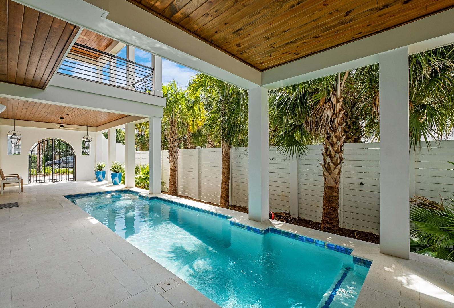 Your private pool sanctuary awaits beneath beautiful wood ceilings, surrounded by swaying palms in this peaceful covered oasis.