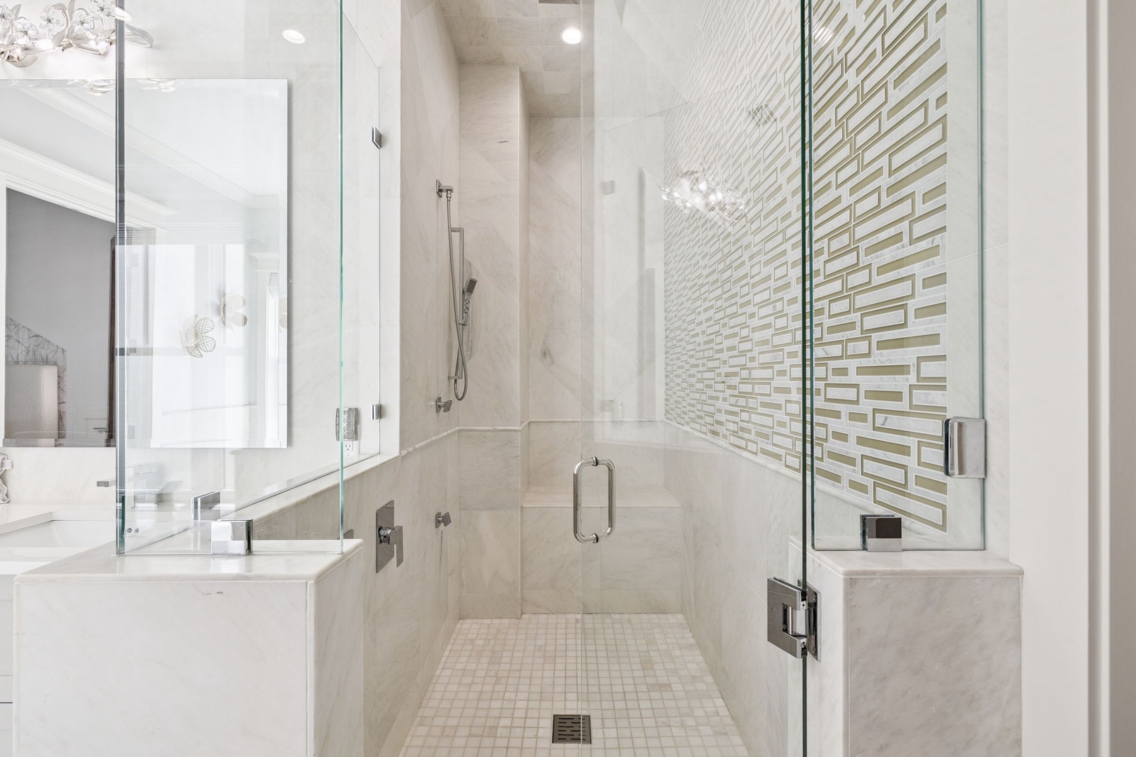 Step into your spa-like glass shower with rainfall head and elegant textured accent wall for the ultimate relaxation.