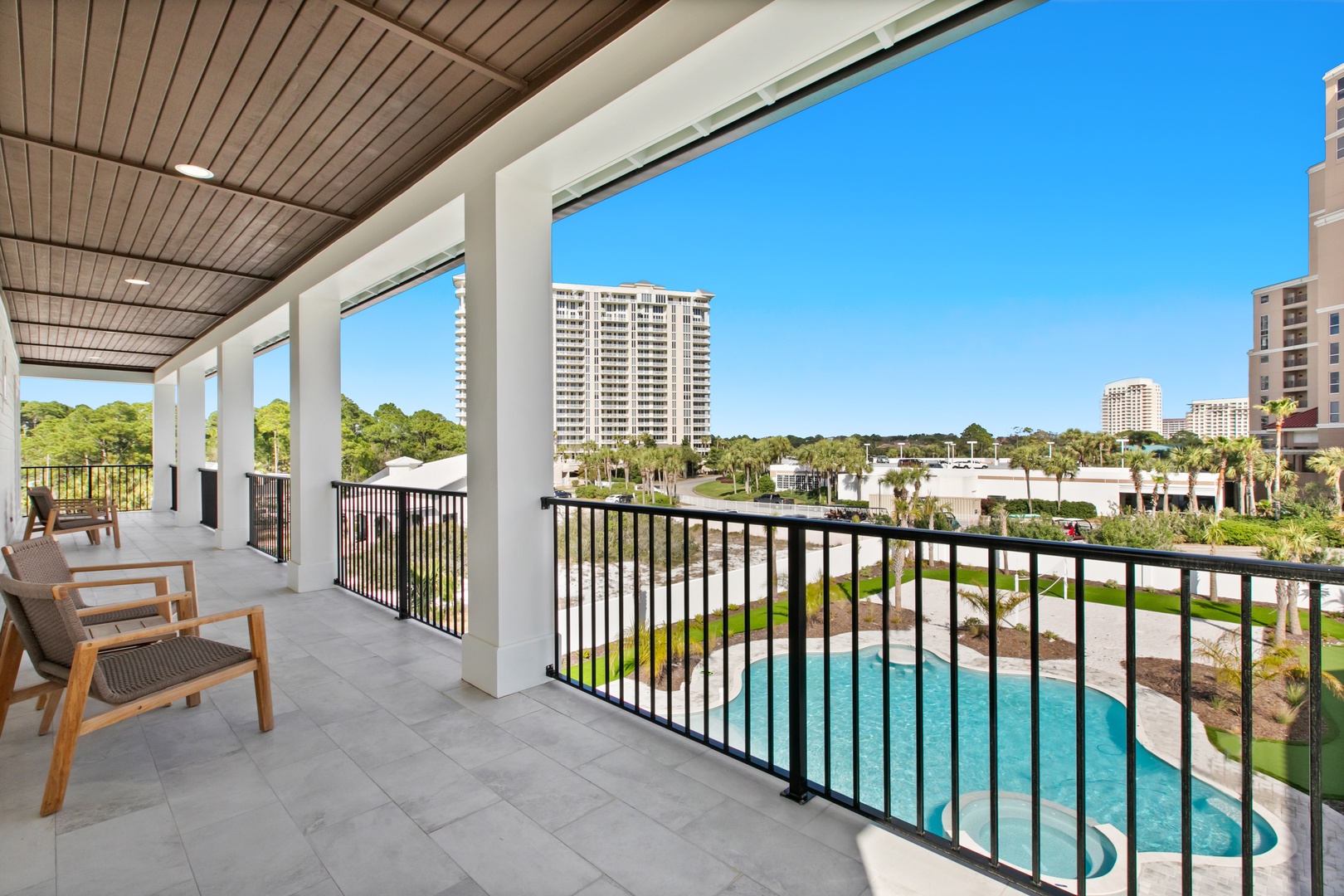 Settle into your covered balcony with sweeping views of the pool and surrounding greenery. The perfect spot to unwind and take in the coastal scenery.