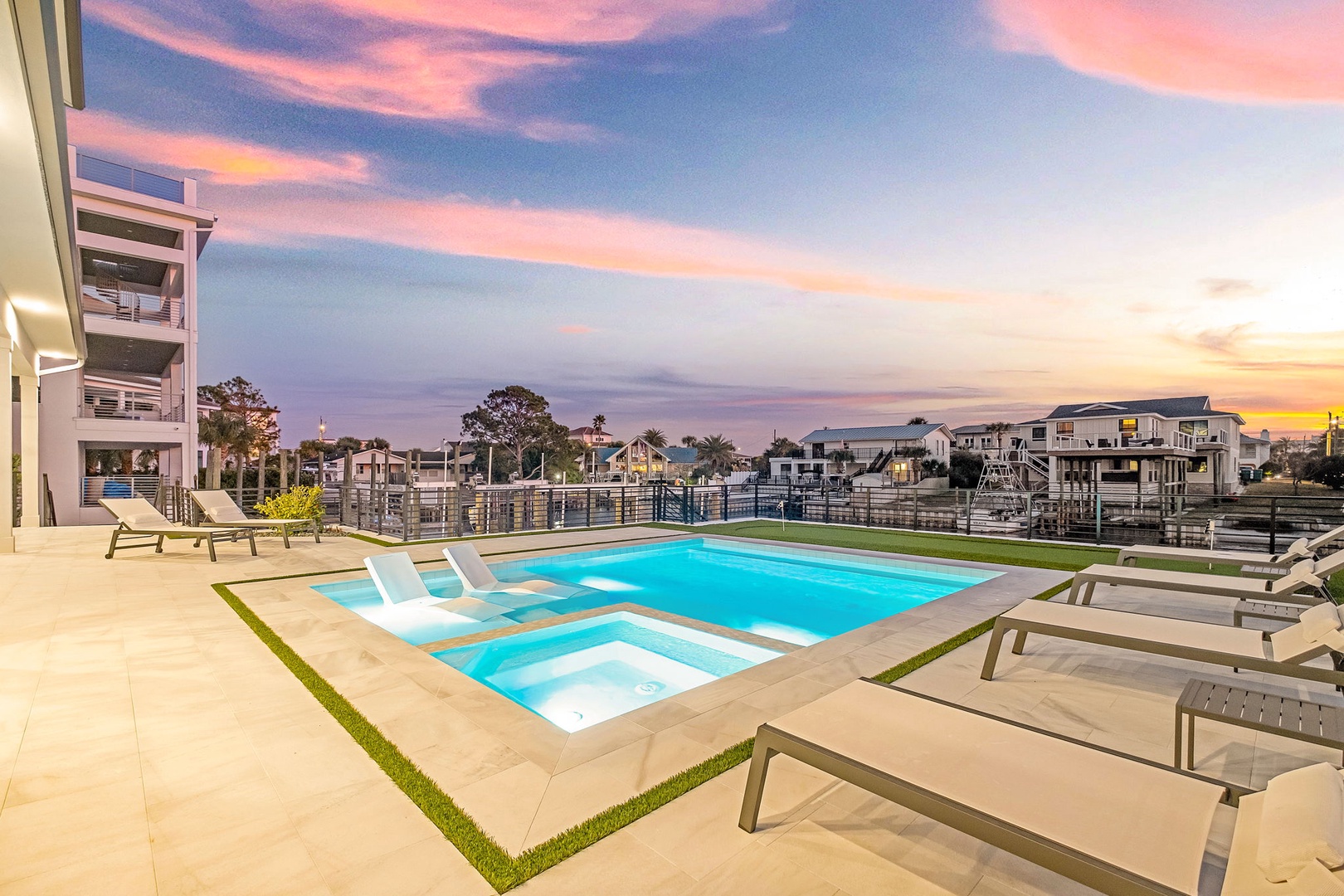 Stunning rooftop pool deck with spa beneath breathtaking sunset skies—perfect for evening relaxation.
