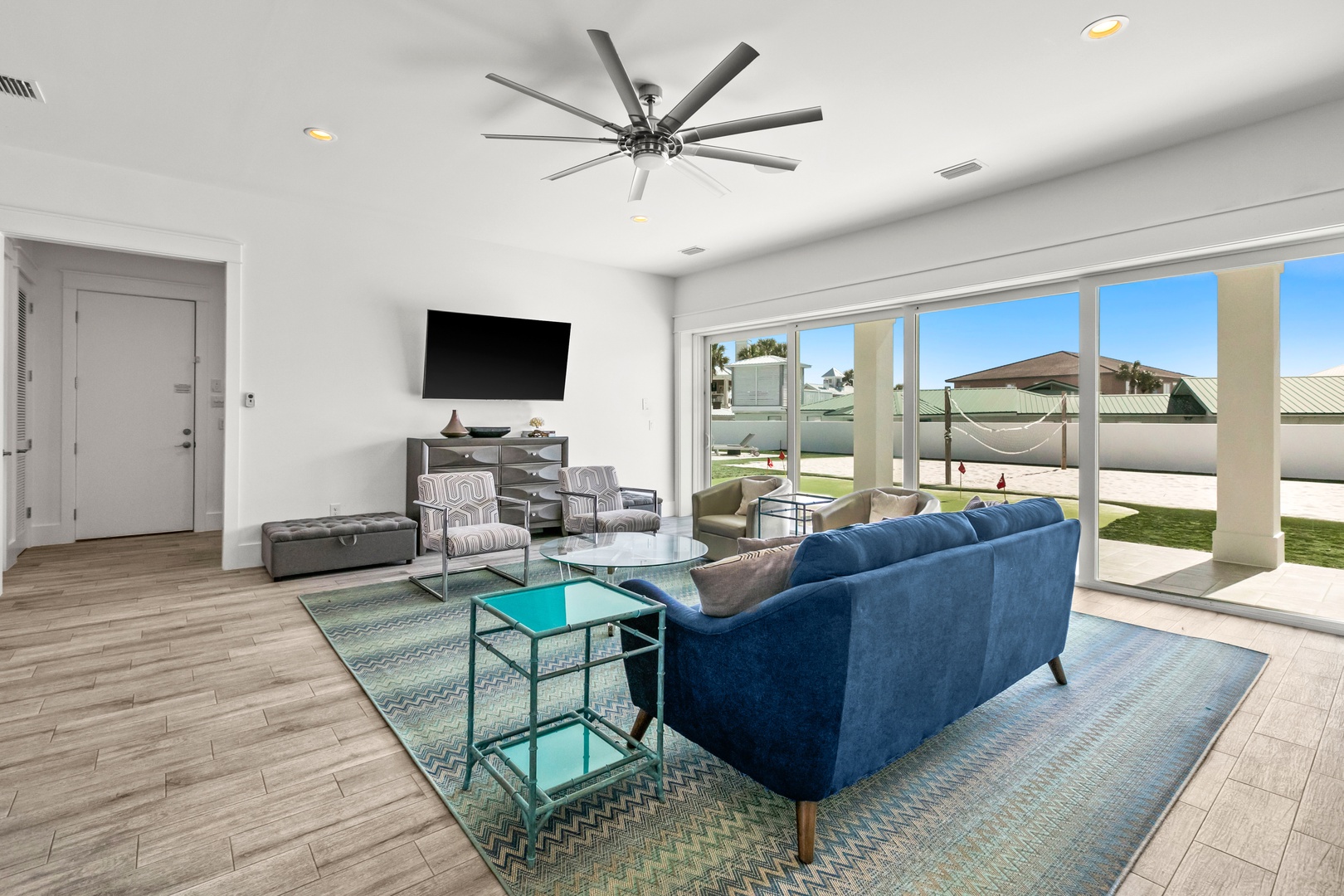 Sink into the plush blue sofa and gaze out at your private pool and hammock—this airy living room opens wide to your own sunny outdoor retreat.