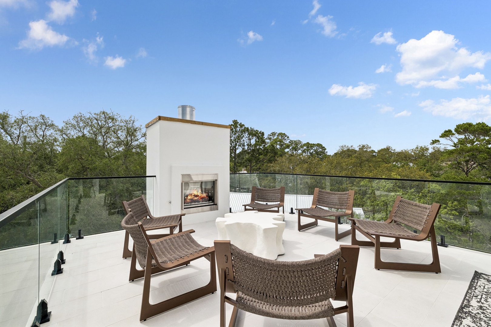 Gather around the rooftop fireplace on breezy evenings, soaking in sweeping treetop views and the glow of the fire under open skies.