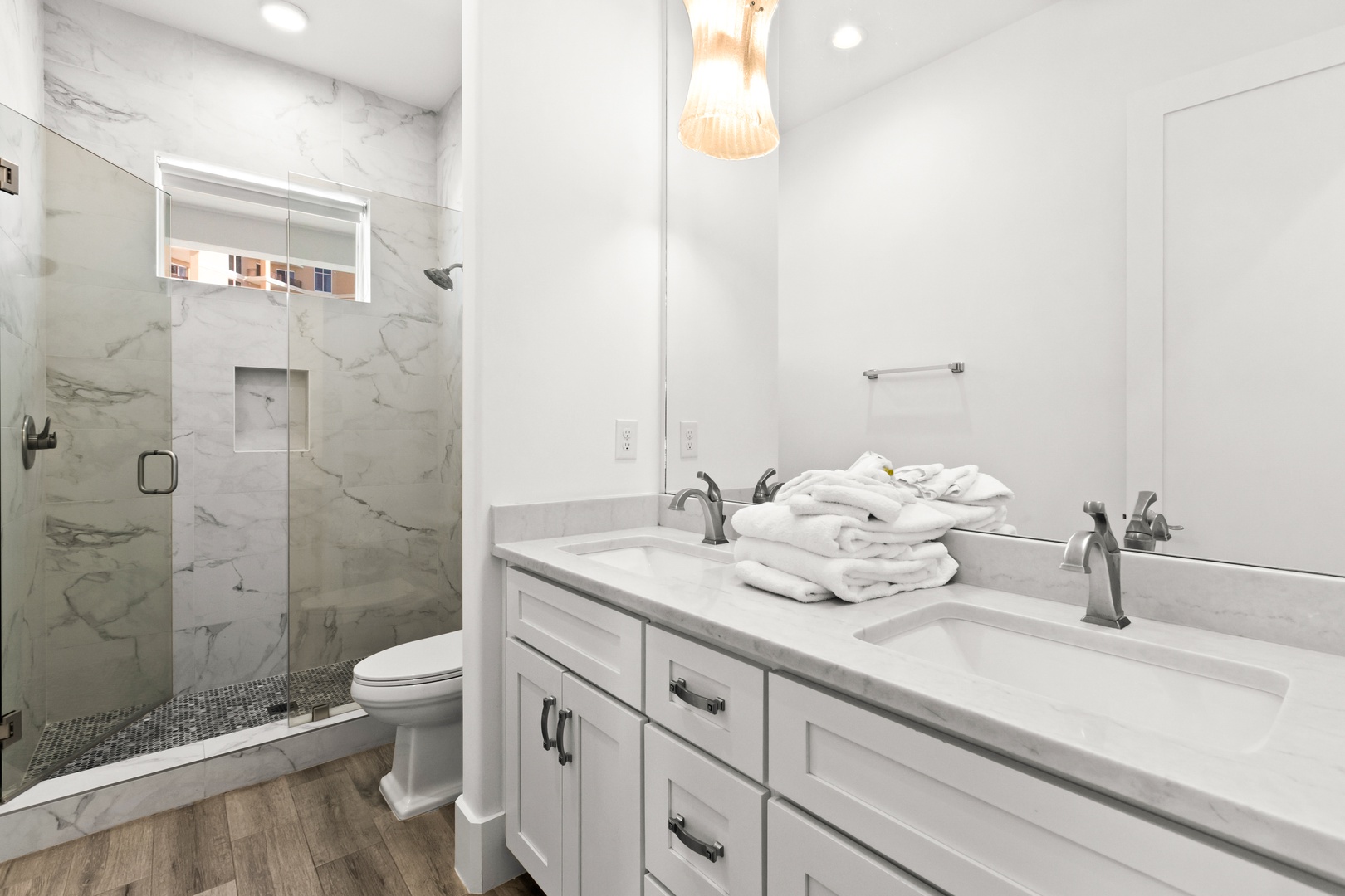 Step into your bright, spotless bathroom with elegant marble tile, dual sinks, and a luxurious walk-in shower—ready for you to unwind after a day of exploring.