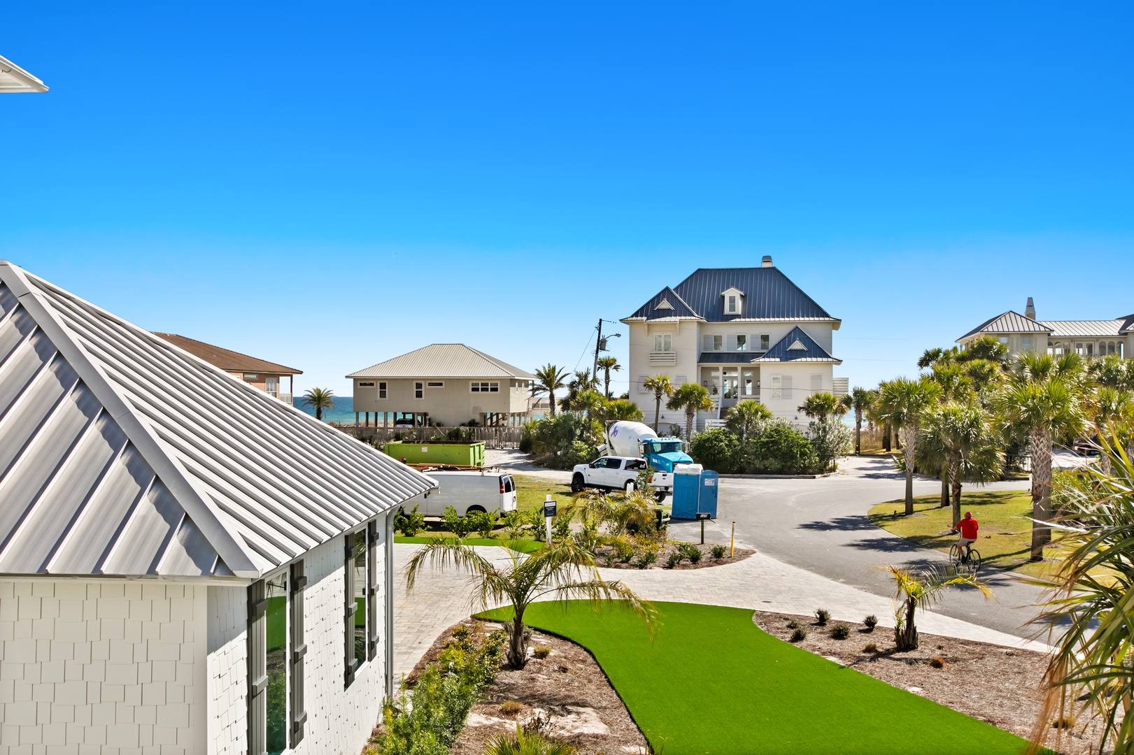 A quiet coastal neighborhood with elevated homes on stilts, palm trees, and glimpses of turquoise water—this peaceful Gulf Coast setting welcomes you home to your beach retreat.
