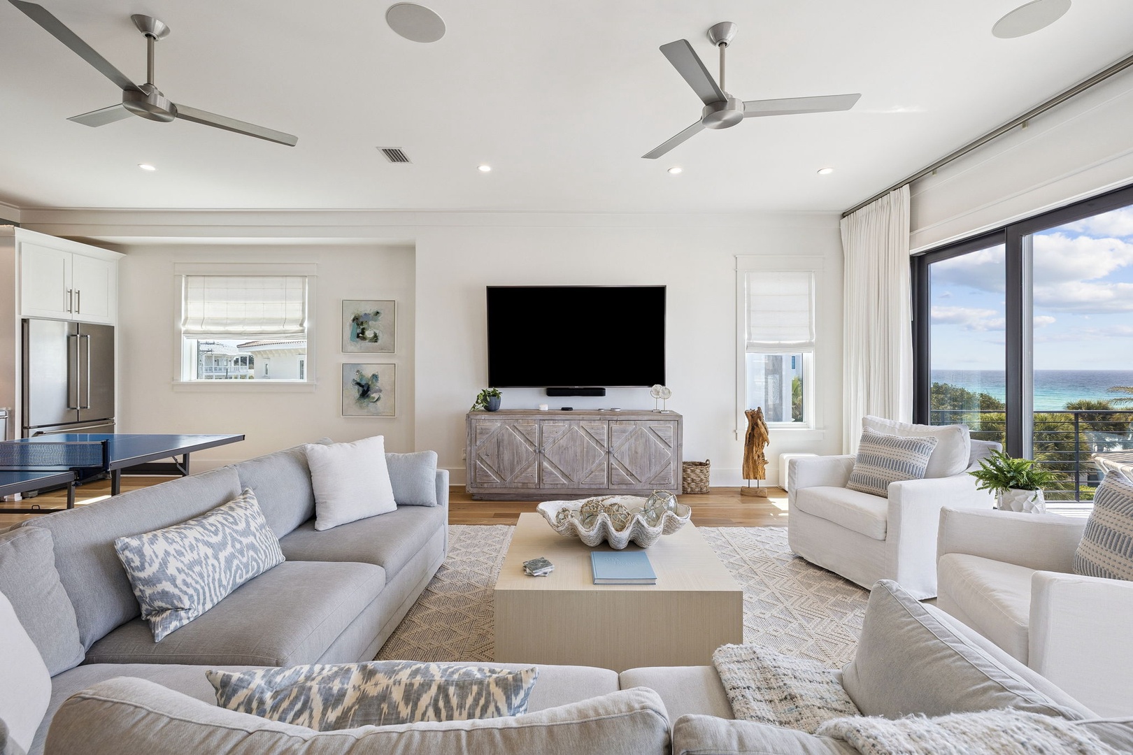 Sink into plush seating while ocean breezes flow through this sophisticated living space, where modern comfort meets stunning water views.