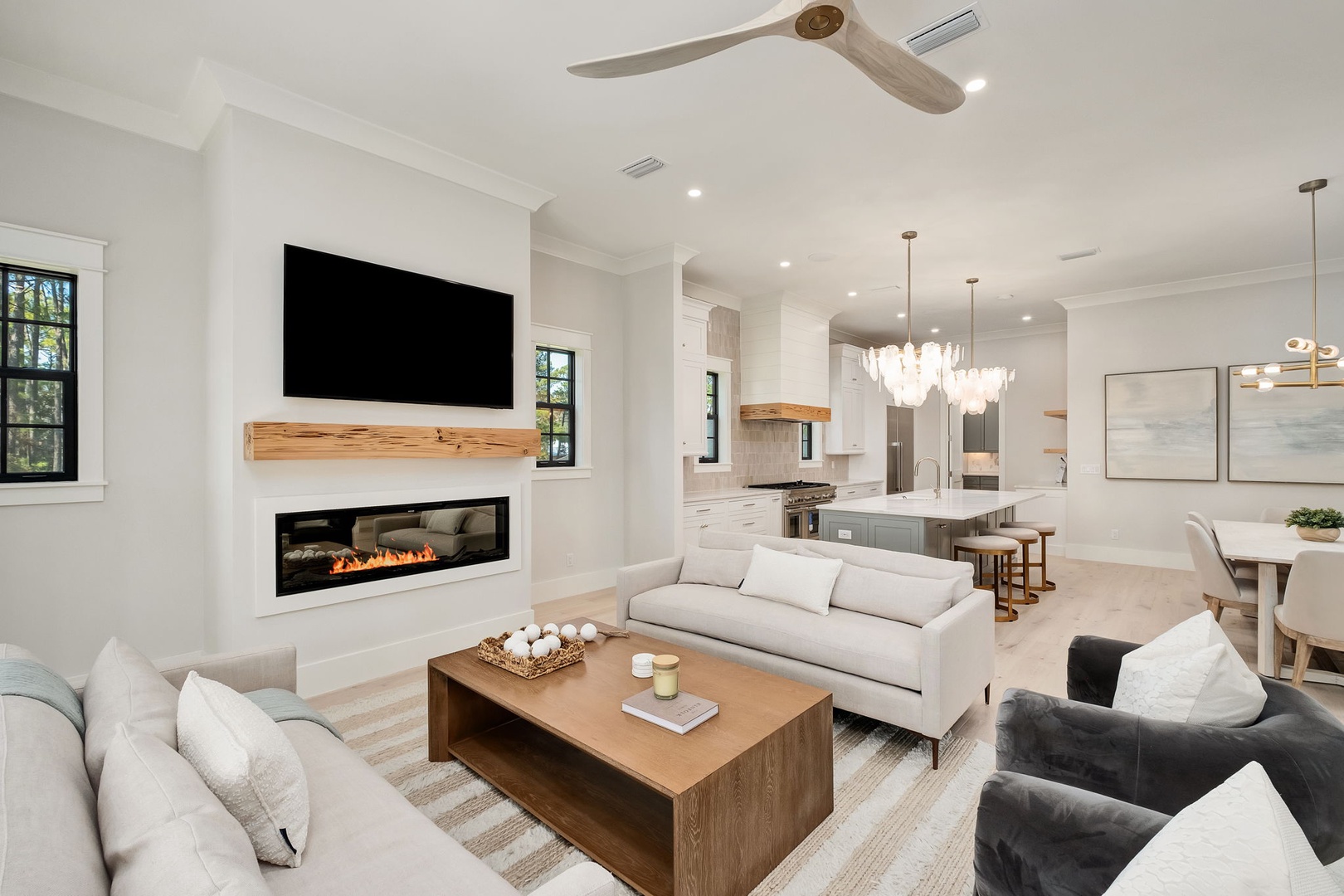 Unwind in this stunning open-concept living space where modern comfort meets elegant design, featuring a cozy fireplace and seamless kitchen flow.