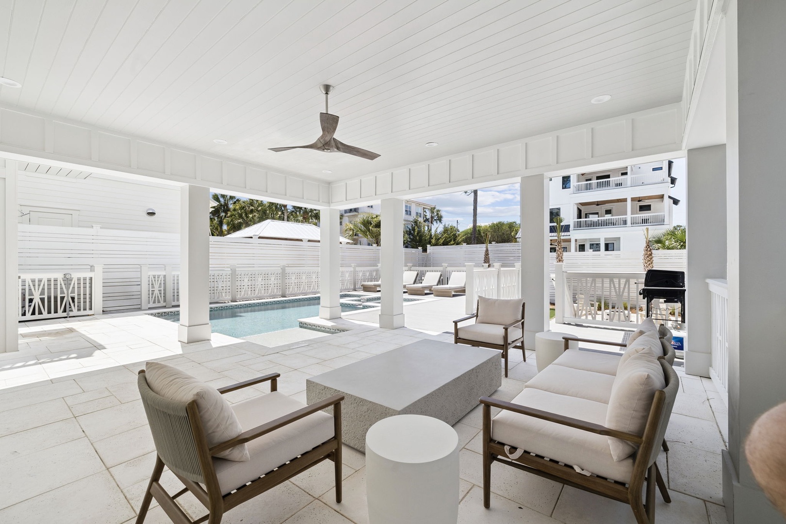 Your elegant poolside lounge beckons with plush seating and tropical views, perfect for morning coffee or evening relaxation.