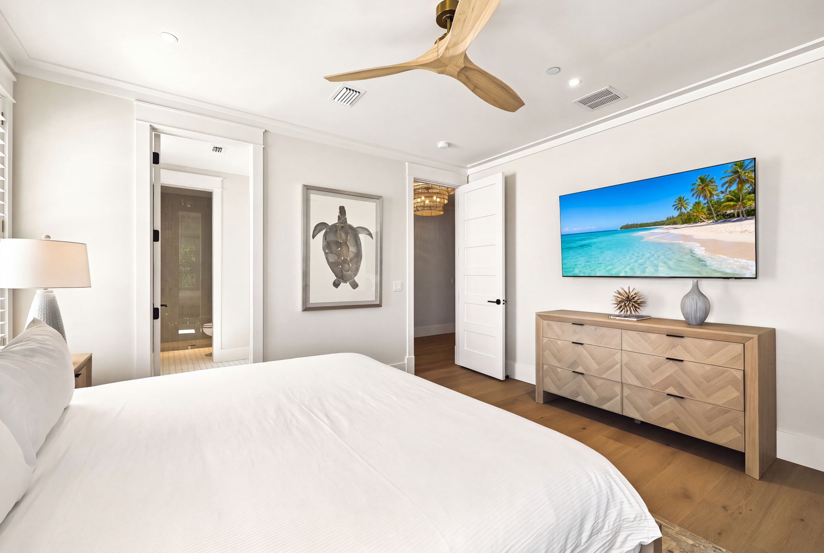 Unwind in your tranquil bedroom with stylish coastal touches, warm wood furnishings, and an en-suite bathroom just steps away. The ceiling fan ensures comfort for restful nights.