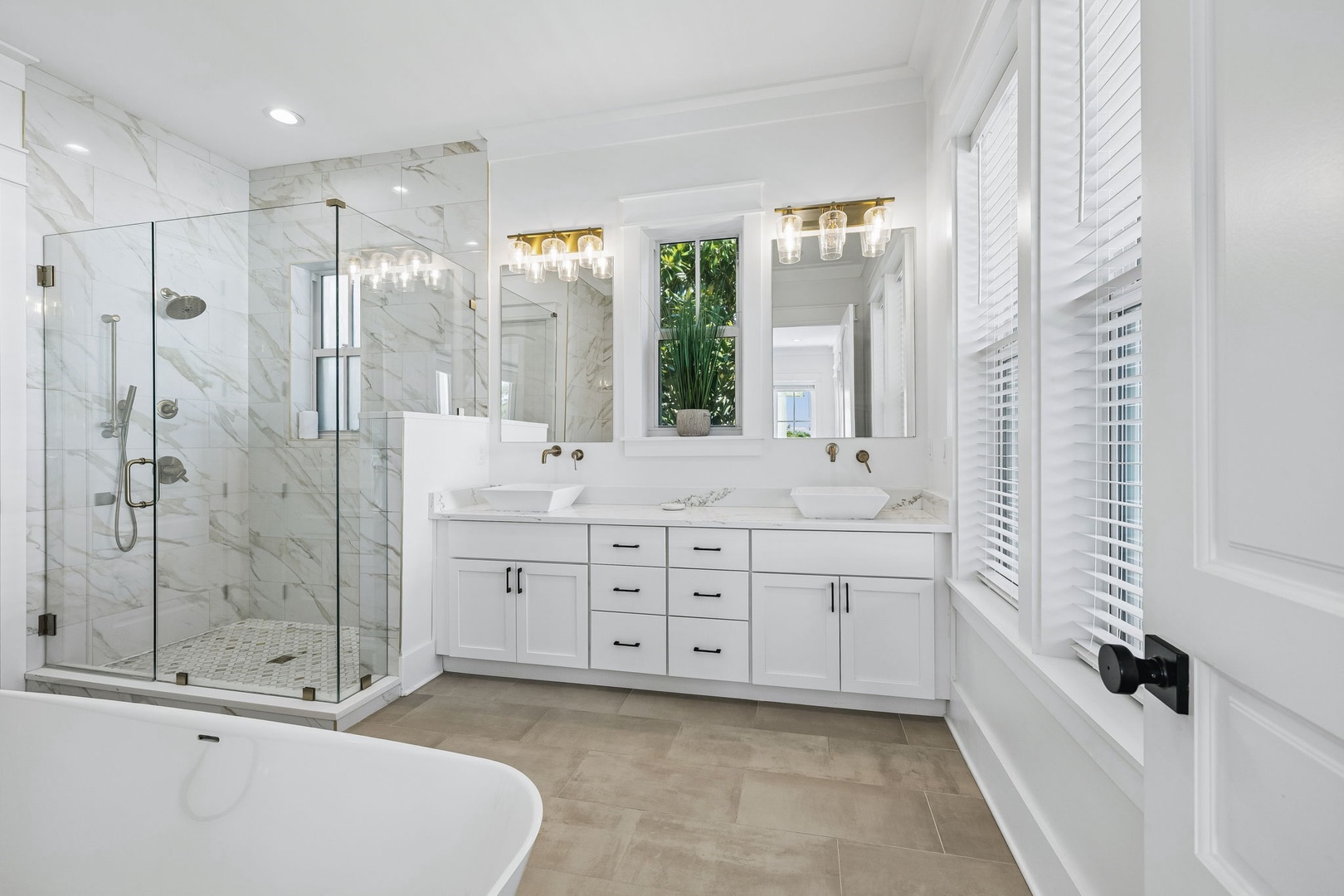 Step into your luxurious marble-clad bathroom with elegant dual vanities, a spacious glass-enclosed shower, and a serene soaking tub—your personal spa awaits.
