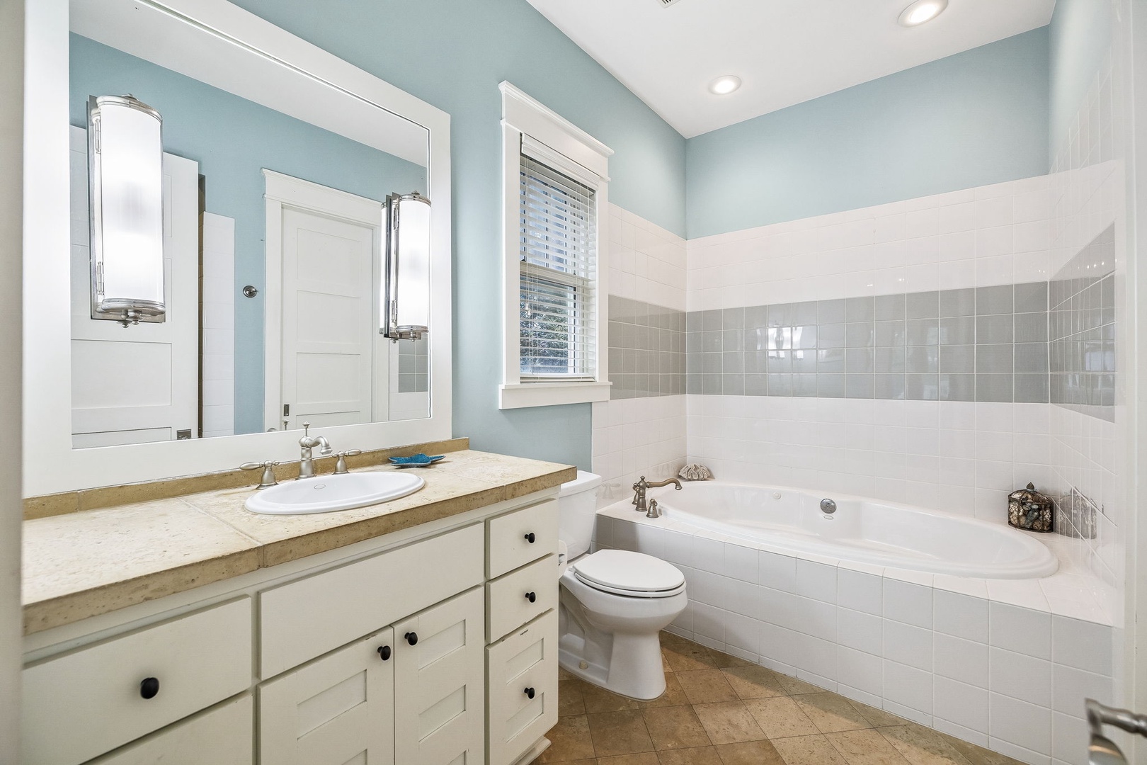 Unwind after your day in this soothing bathroom, where soft coastal hues and abundant natural light create a peaceful retreat. Soak in the spacious tub and refresh with ease at the generous vanity—your personal oasis awaits.