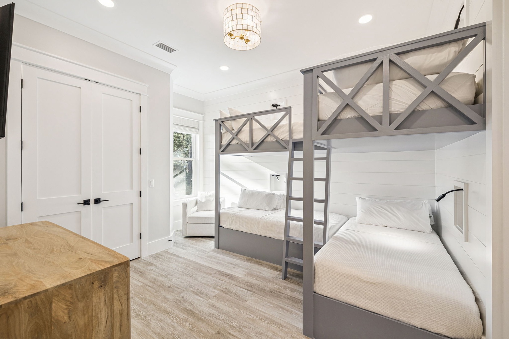 Your kids will love these stylish bunk beds in this bright, cheerful room with crisp white linens and modern touches.