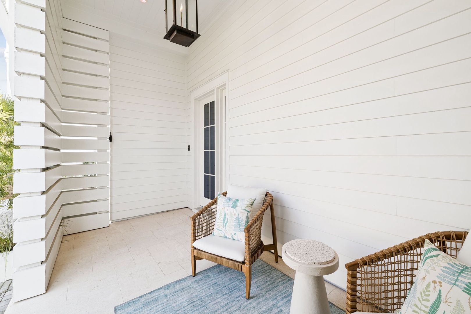 Unwind on your private covered patio with coastal-inspired wicker seating and tropical cushions—your perfect spot for morning coffee.