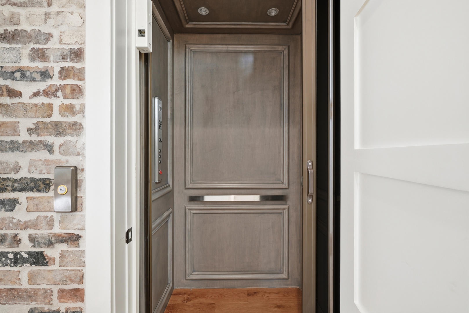 This elegant elevator features a sophisticated wood-paneled interior with detailed molding and warm lighting, providing convenient access throughout the property.
