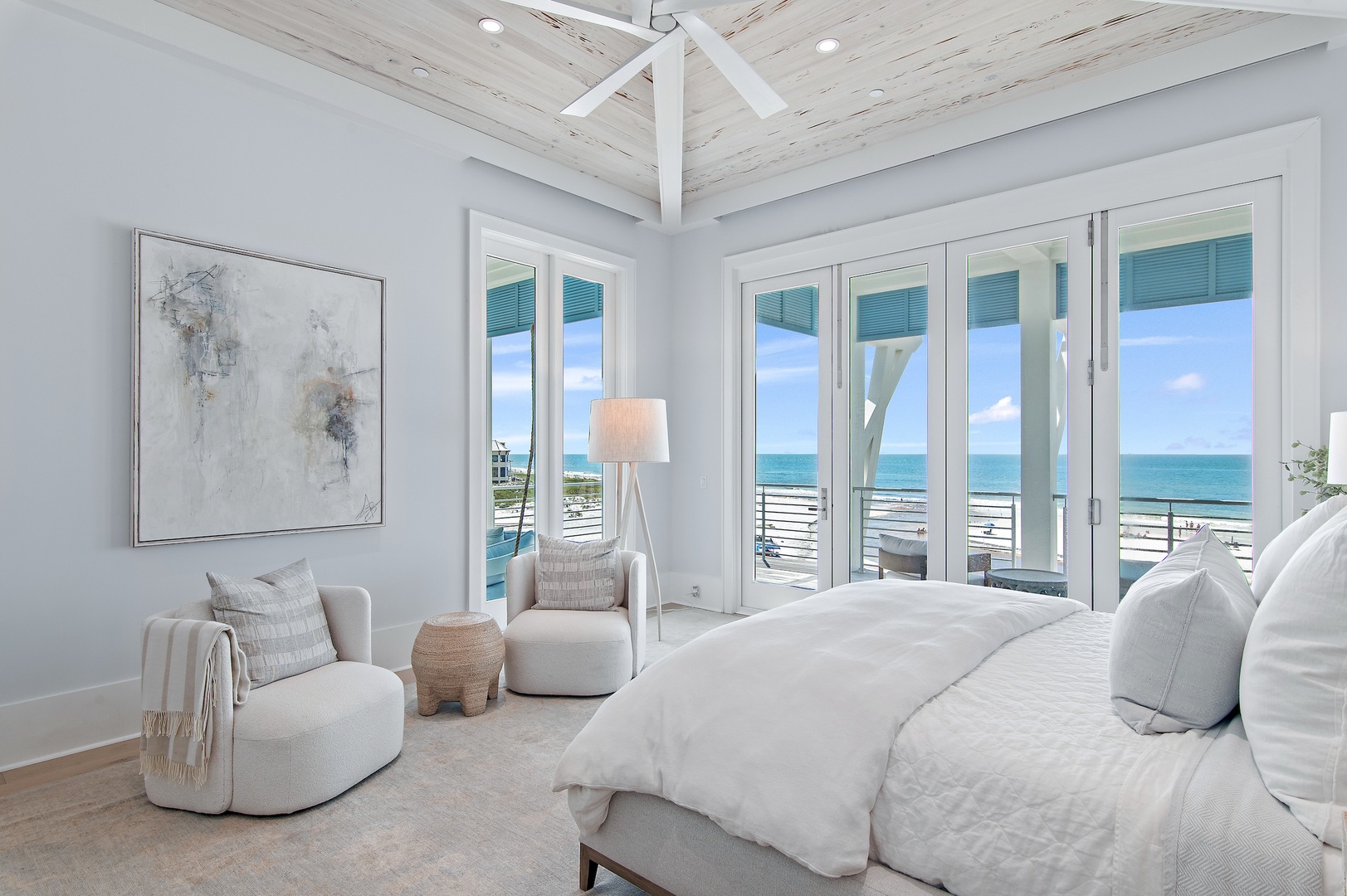 Wake up to stunning turquoise waters framed by floor-to-ceiling windows. Your private retreat features plush white bedding, coastal accents, and direct ocean breezes—a serene escape designed for ultimate relaxation.