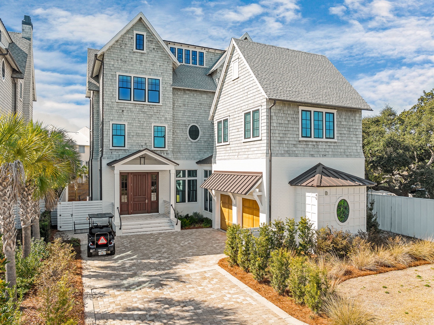Stunning coastal-style home featuring elegant shingle siding, beautiful landscaping, and thoughtful architectural details throughout the property.