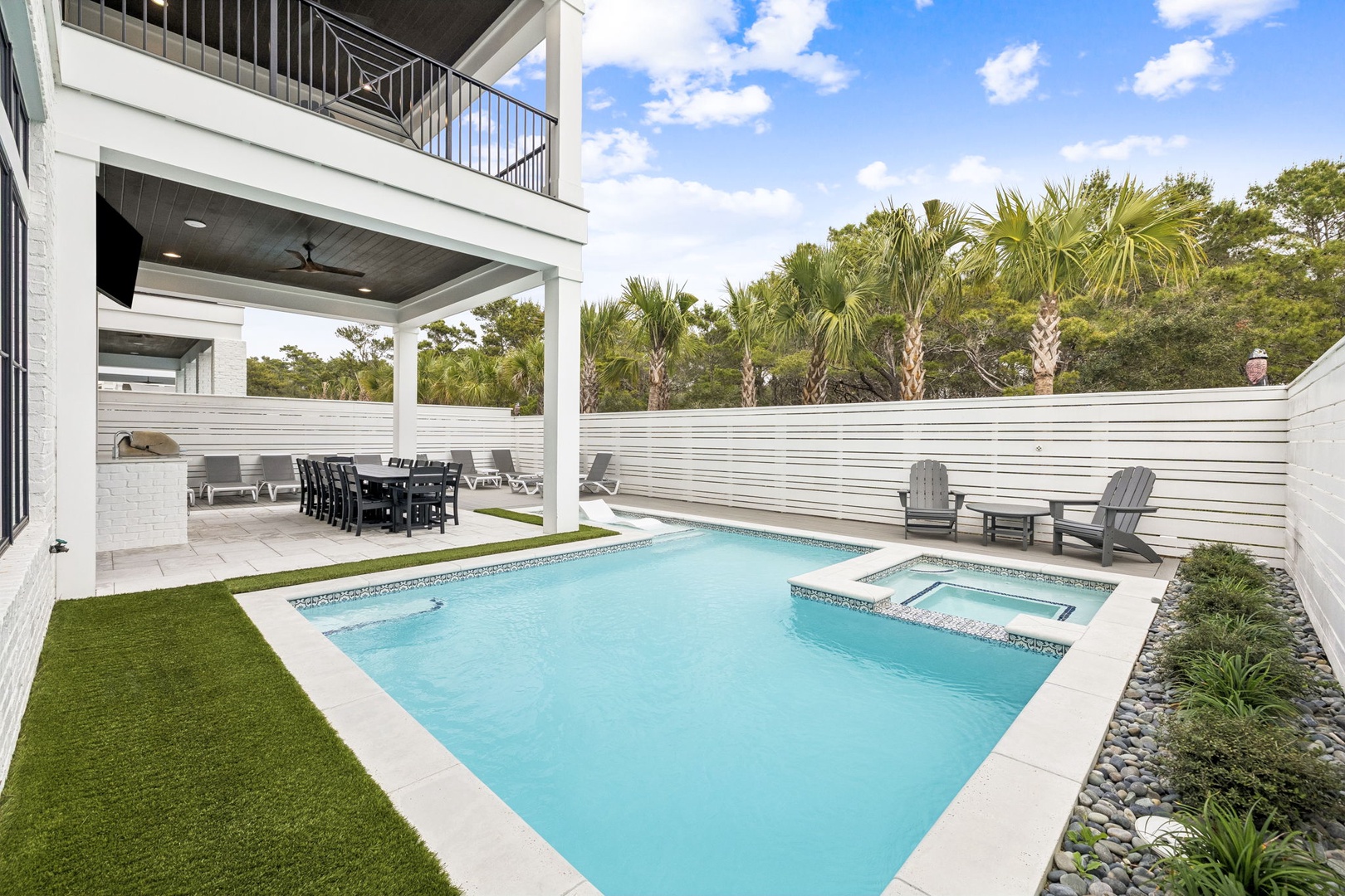 Your private pool and hot tub await, surrounded by tropical palms and a spacious covered dining area for perfect outdoor entertaining.