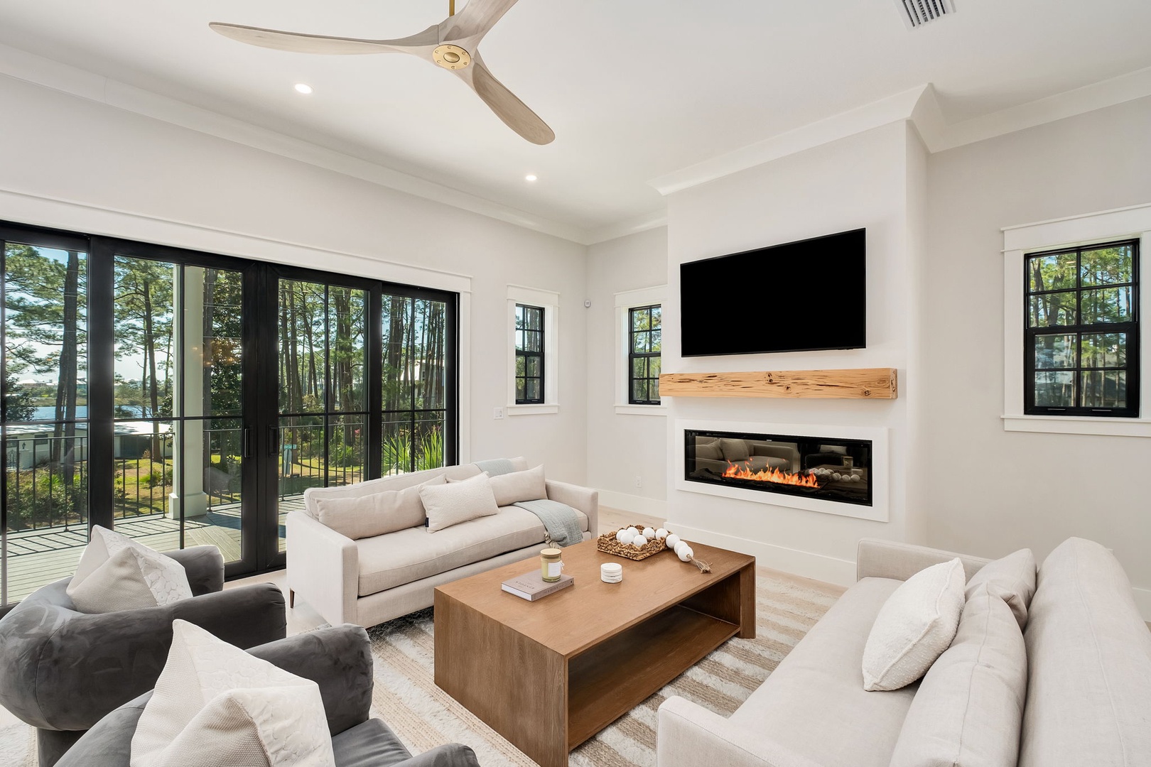 Sink into plush sofas by your modern fireplace while forest views frame your retreat through expansive windows.