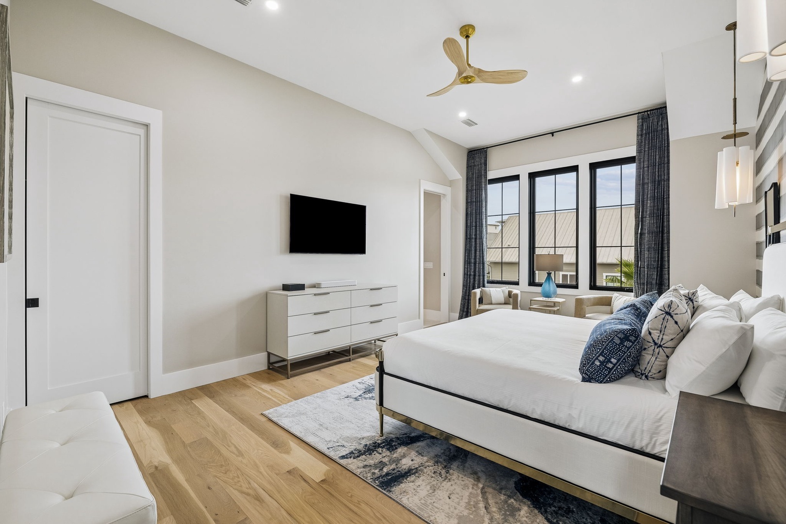 Sink into a plush bed with crisp linens as natural light pours through expansive windows. Your private retreat features modern furnishings, a cozy seating nook, and a calming neutral palette.
