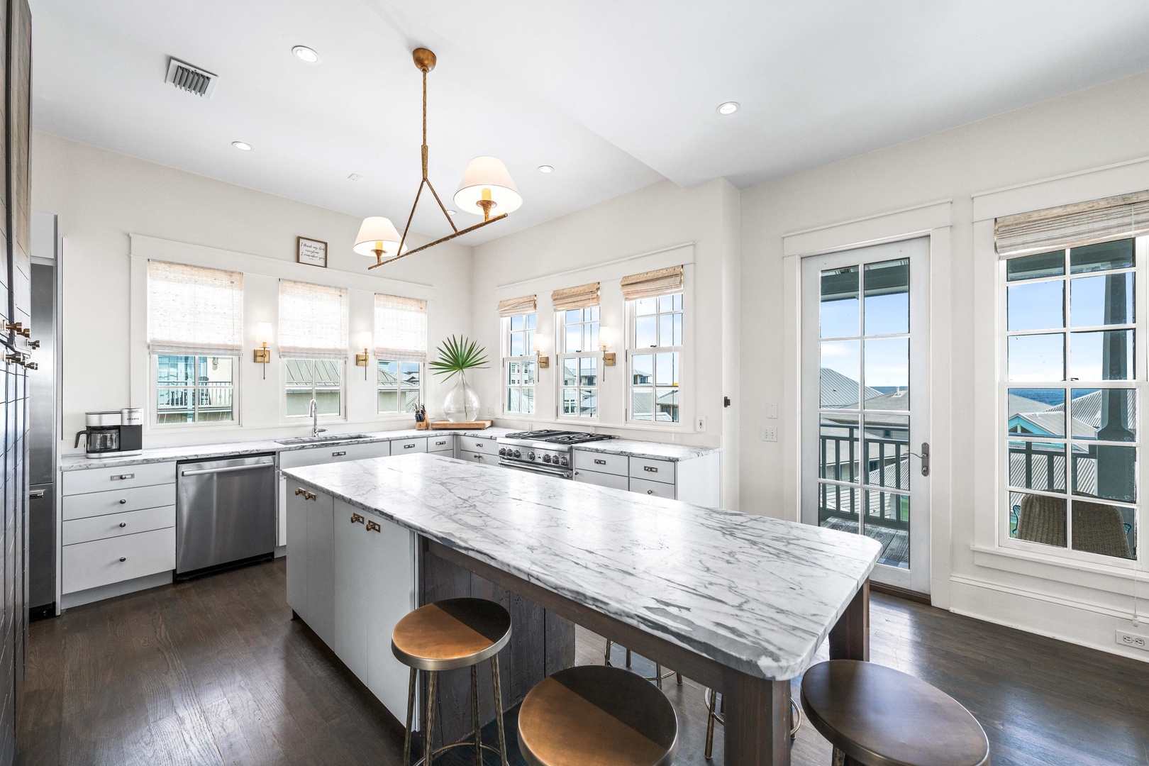 Cook in your gourmet kitchen with marble island, modern appliances, and ample natural light streaming through windows.