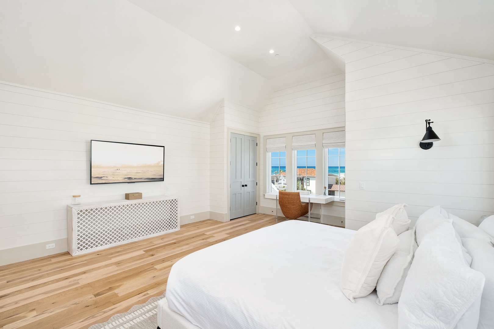 Drift off to sleep in your bright bedroom where crisp white linens meet warm wood floors and ocean views frame your morning wake-up.