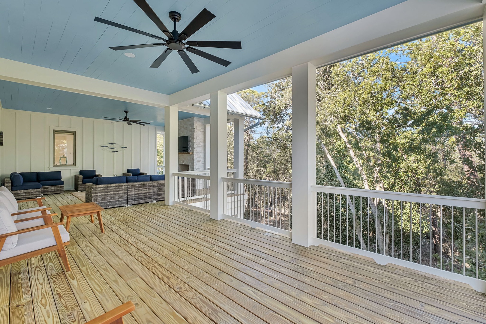 Unwind on your spacious covered deck with ceiling fans, outdoor seating, and peaceful treetop views.