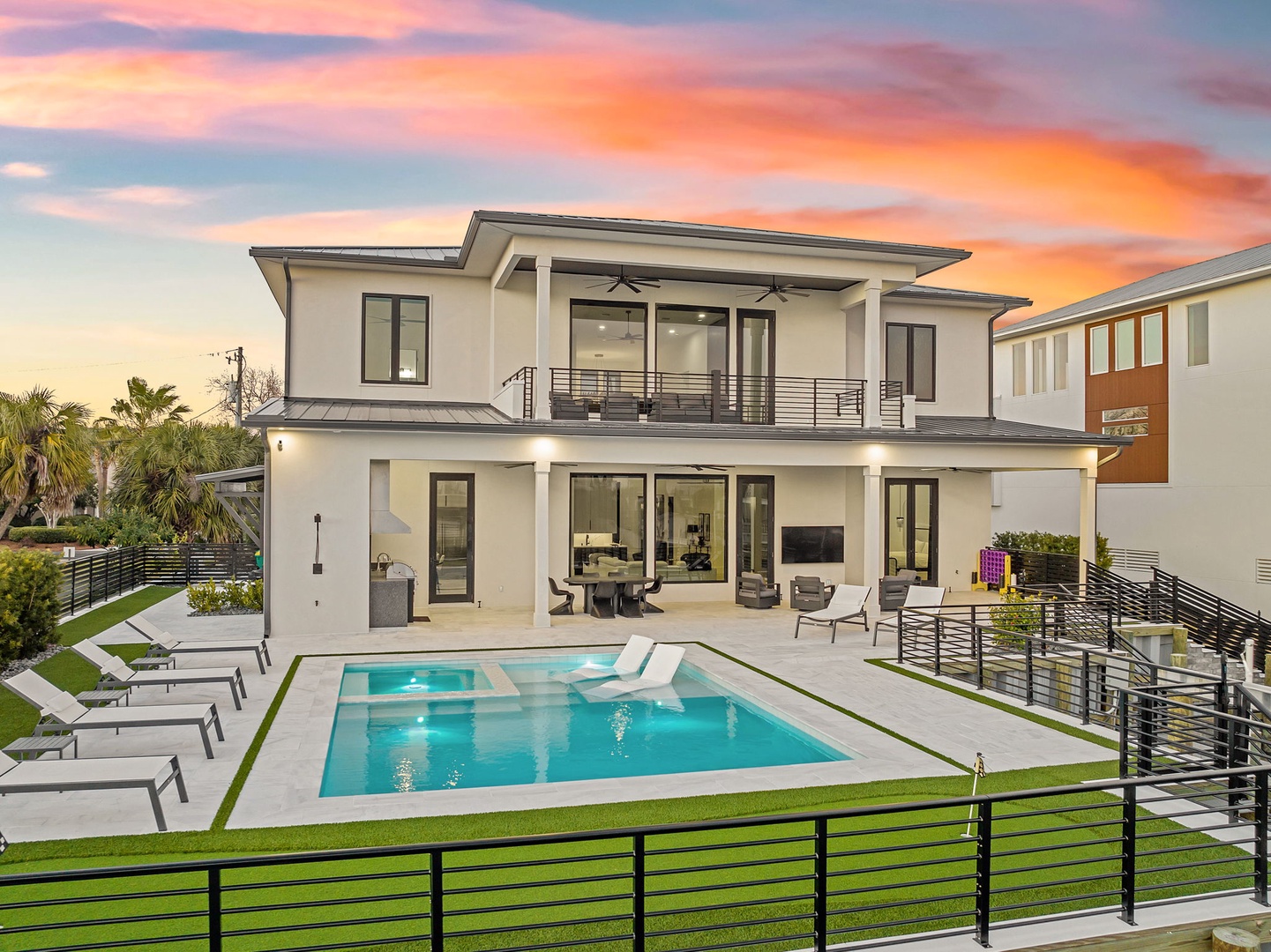 Modern two-story vacation home with private pool and stunning sunset backdrop in an upscale neighborhood.