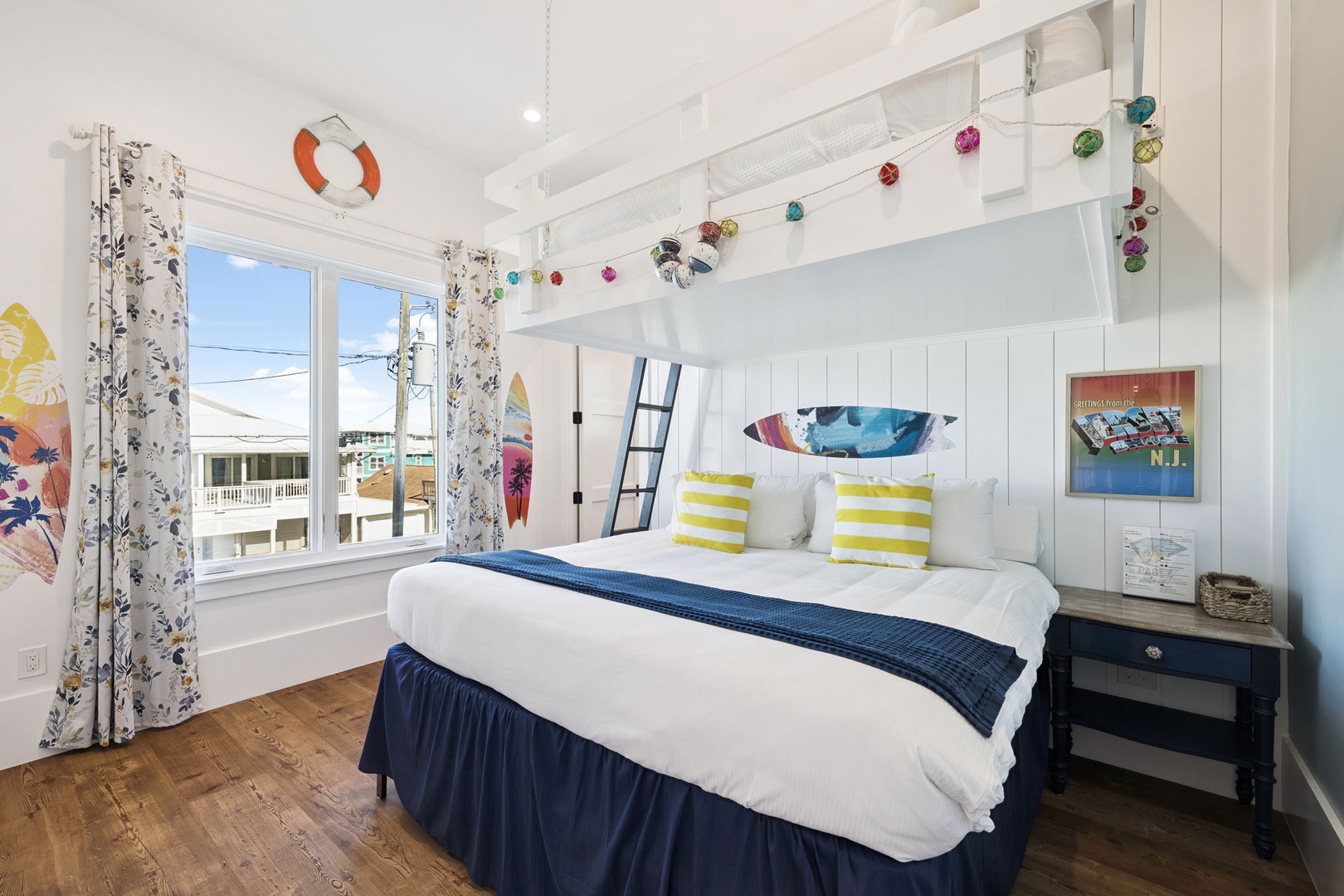 Drift into dreams in this charming coastal bedroom with nautical touches, colorful string lights overhead, and cheerful yellow striped pillows awaiting your arrival.