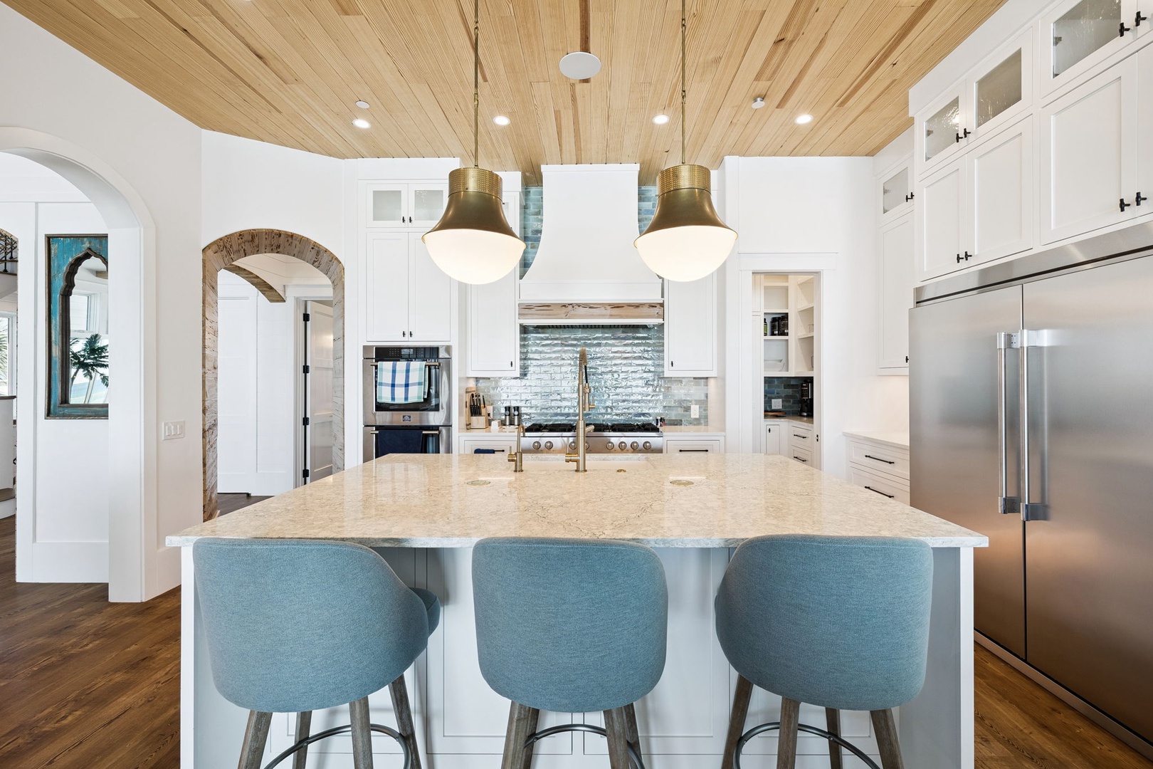 Cook and connect at your spacious kitchen island, where warm wood ceilings meet modern appliances for memorable meal preparation.