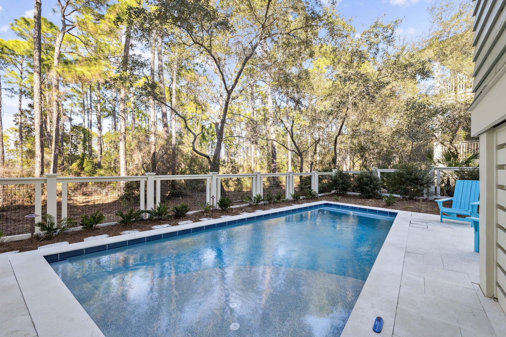 Dive into your private oasis, where crystal-clear waters shimmer beneath towering trees and peaceful woodland views create the perfect backdrop for relaxation.