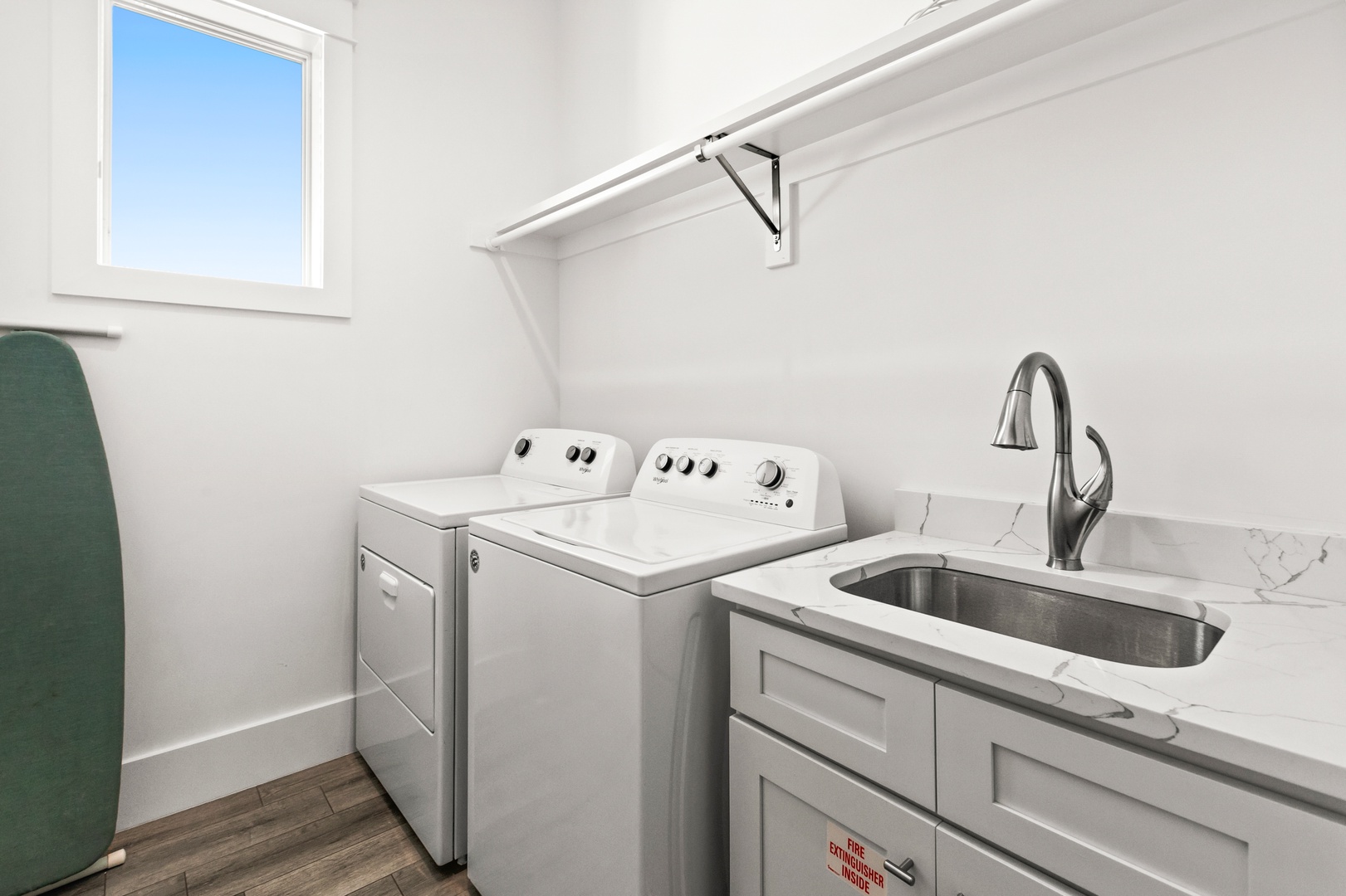 Your laundry day just got easier with a bright, dedicated space featuring a full-size washer and dryer, plenty of hanging room, and a handy utility sink for all your needs.