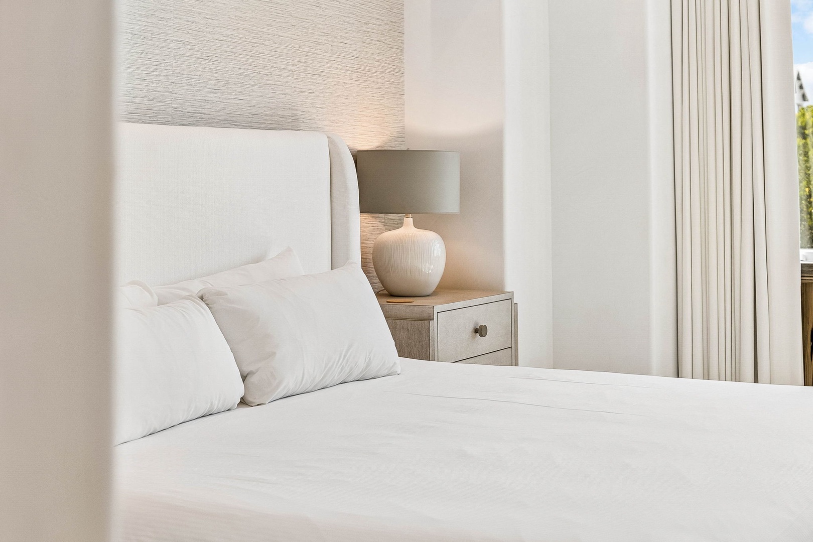 Sink into crisp white linens and serene coastal elegance. Your peaceful retreat features soft lighting and thoughtful touches for ultimate relaxation.