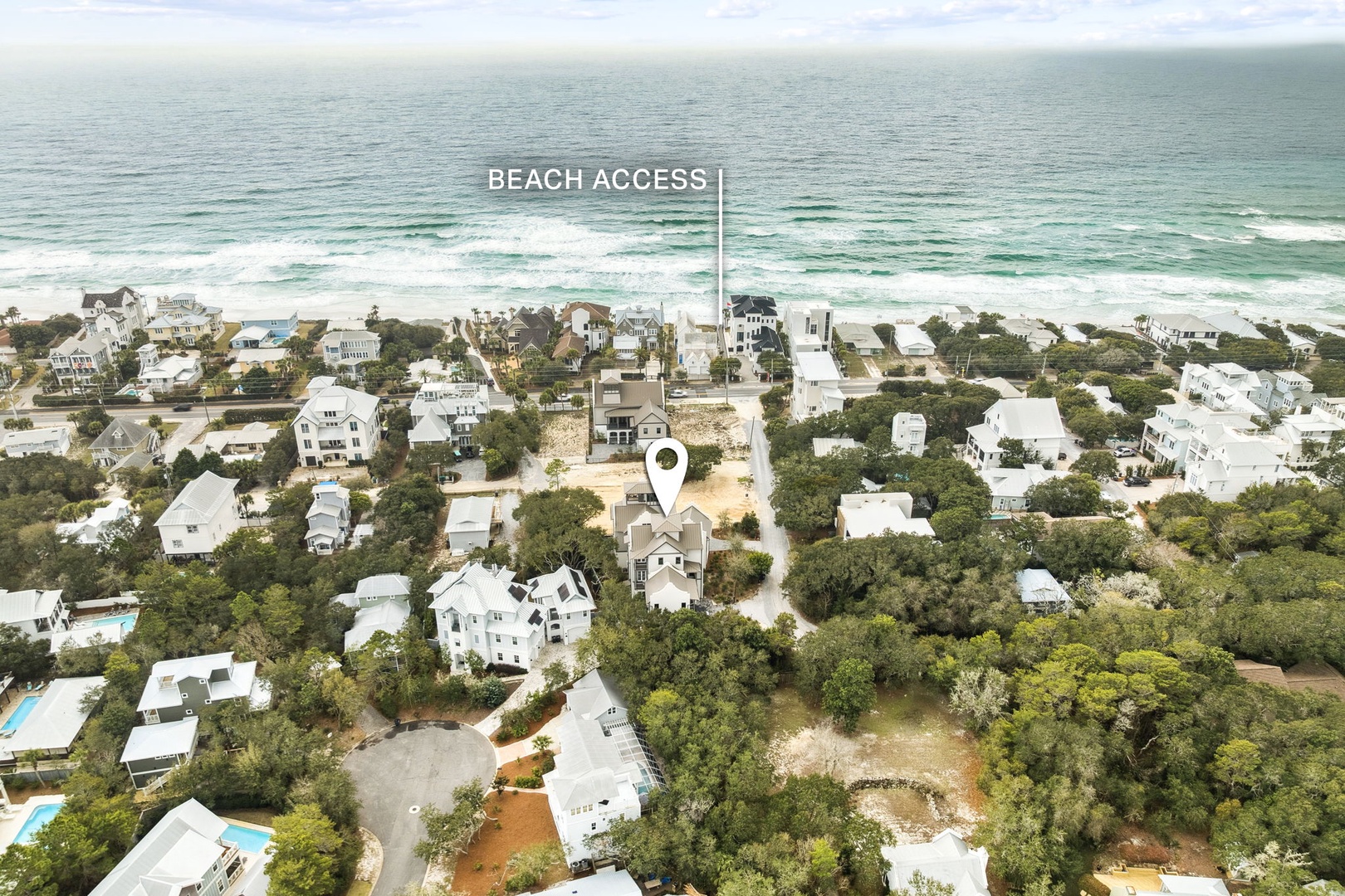 Aerial view of beachfront community with easy beach access and coastal neighborhood surrounded by lush greenery.