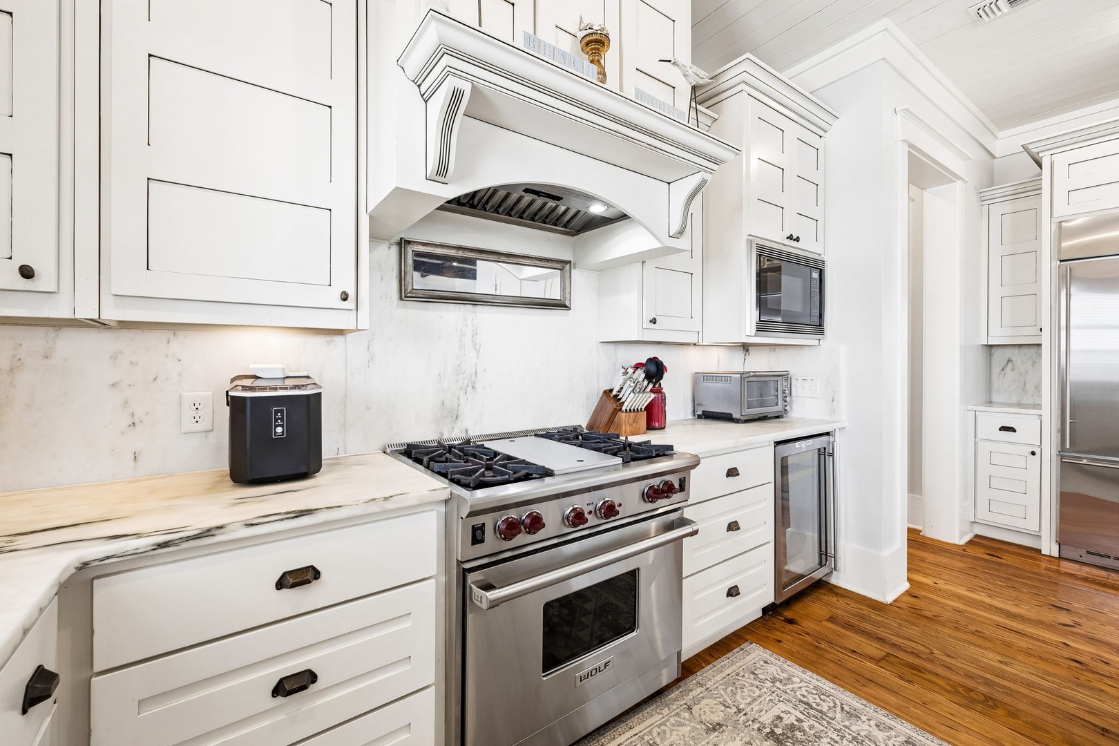 Your culinary sanctuary awaits, with gleaming professional-grade appliances, marble countertops, and elegant white cabinetry—every detail designed to inspire your inner chef and make meal prep a joy.