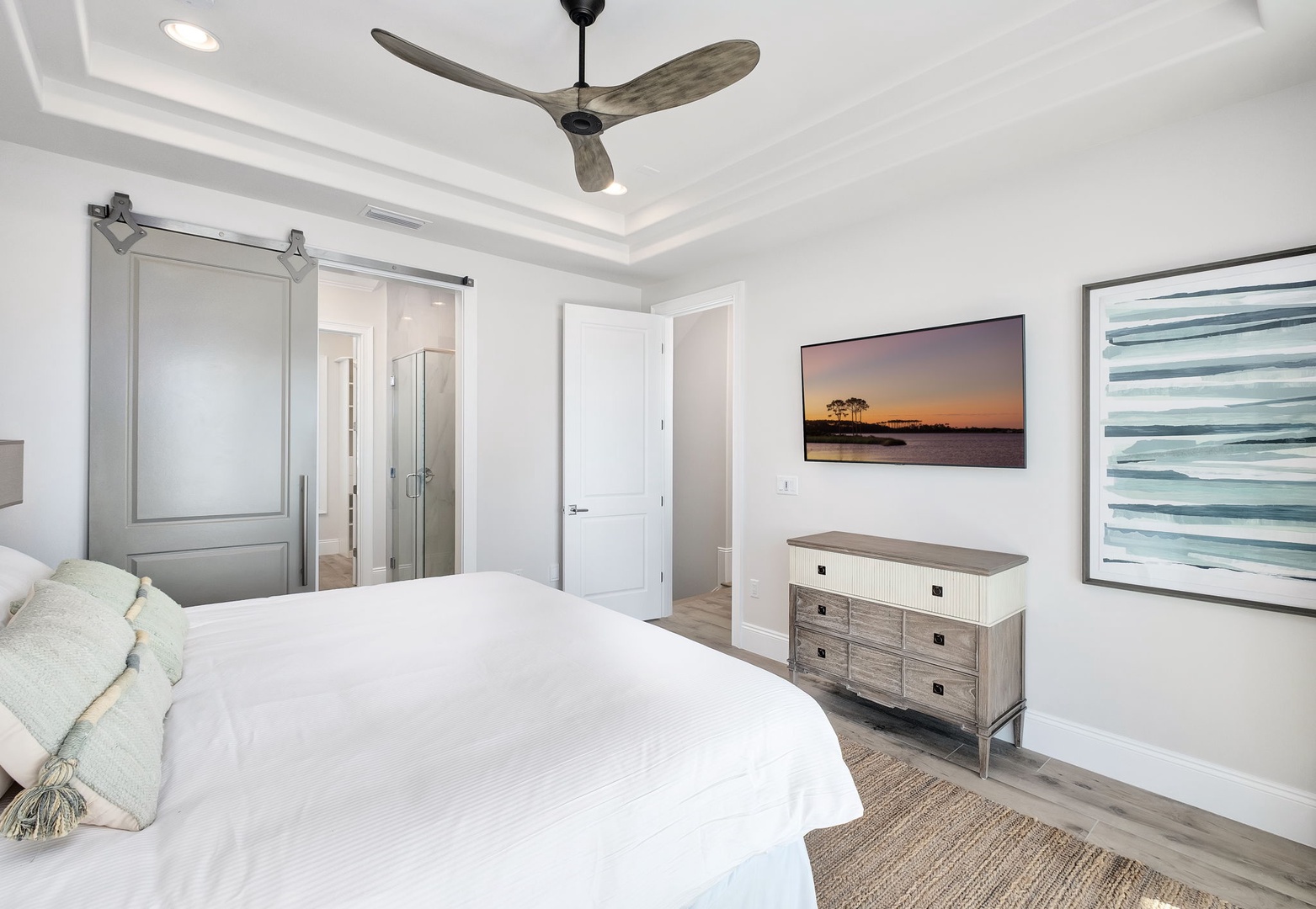 Drift off in your serene bedroom sanctuary with coastal artwork, ceiling fan comfort, and spa-like ensuite access.