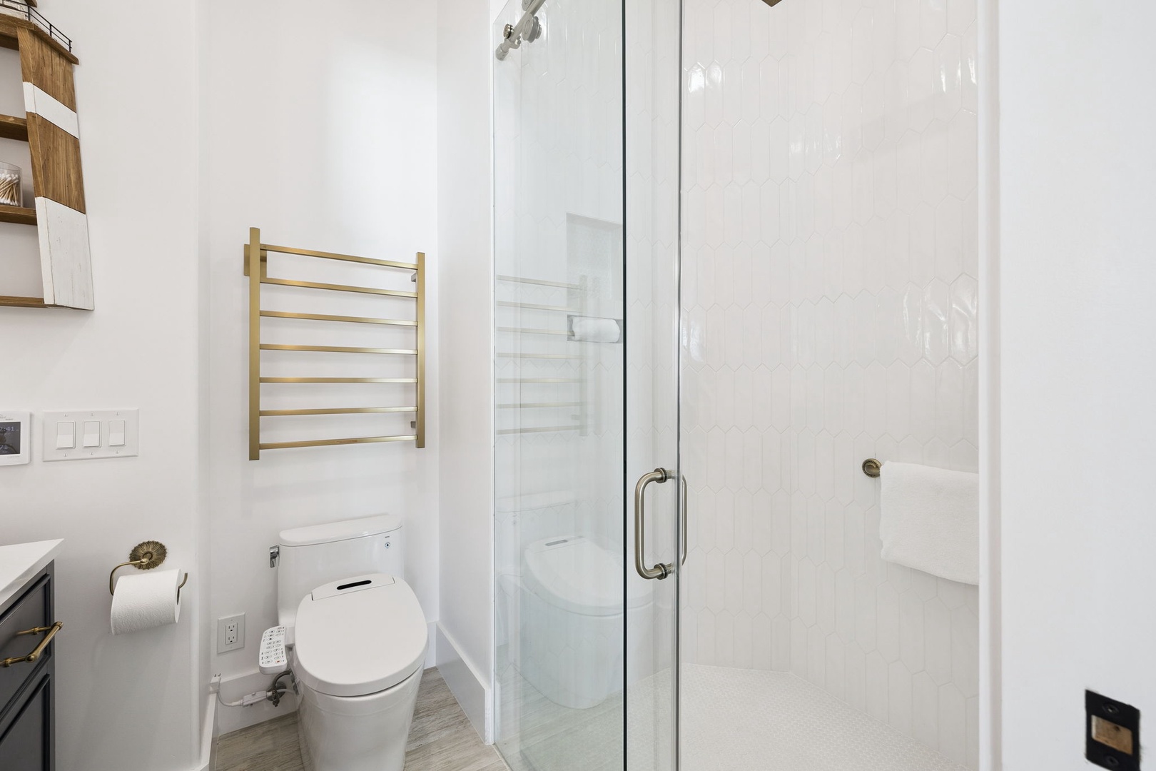 Step into your sleek modern bathroom featuring a spacious glass shower and stylish brass towel warmer for ultimate comfort.