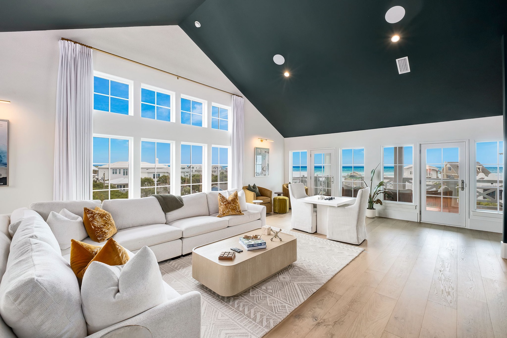 Unwind in your stunning living room where soaring ceilings and floor-to-ceiling windows frame gorgeous ocean views. The spacious layout features plush seating and abundant natural light—your perfect coastal retreat.