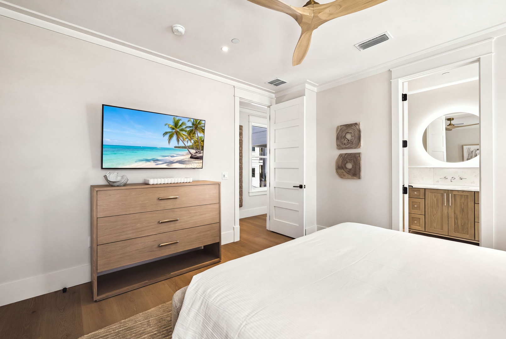 Slip into crisp linens and unwind in your serene bedroom, complete with coastal décor, warm wood accents, and a private ensuite for added comfort.