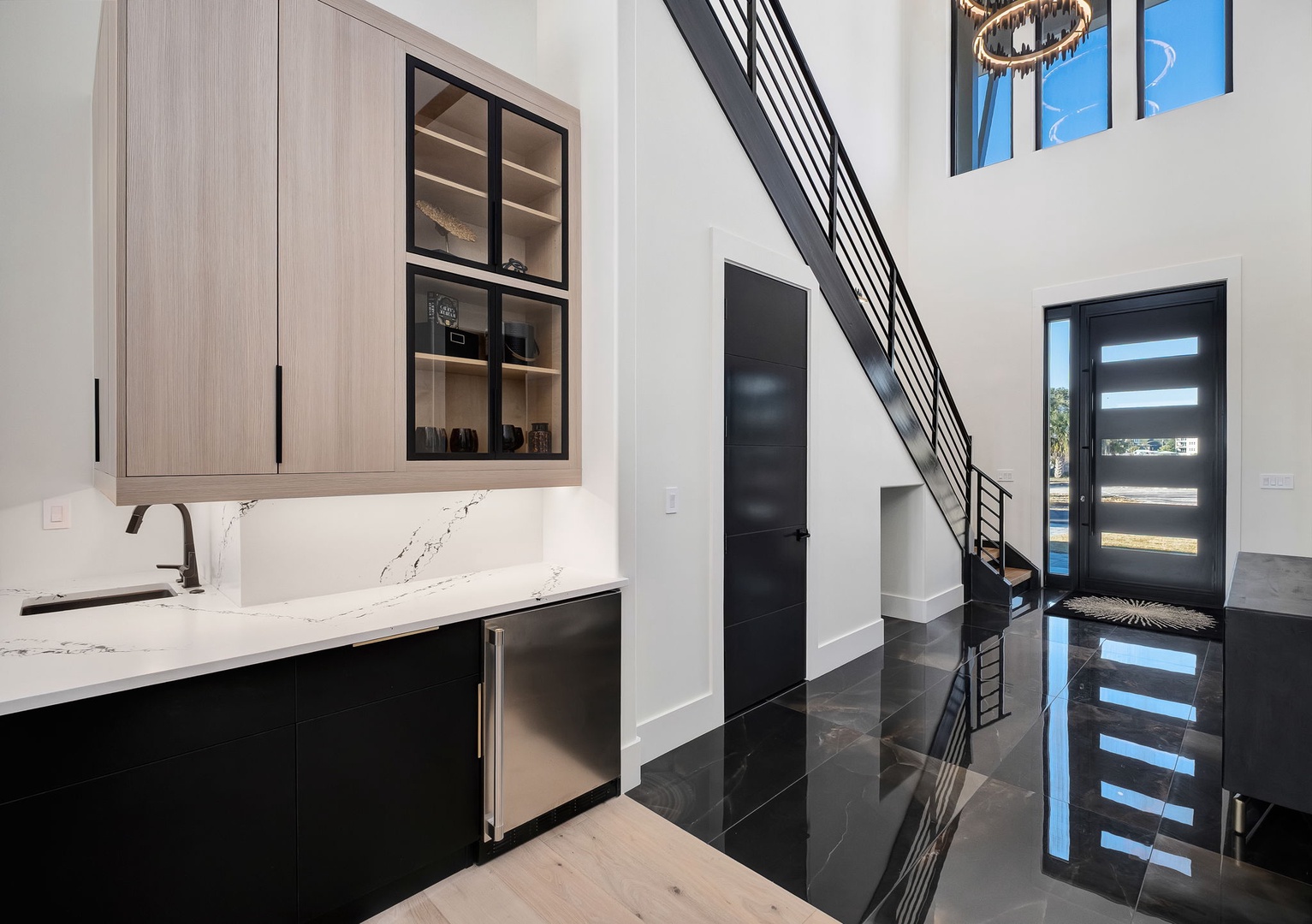 Step into your sleek open-concept space where modern design meets luxury, featuring stunning marble countertops and dramatic stairs.