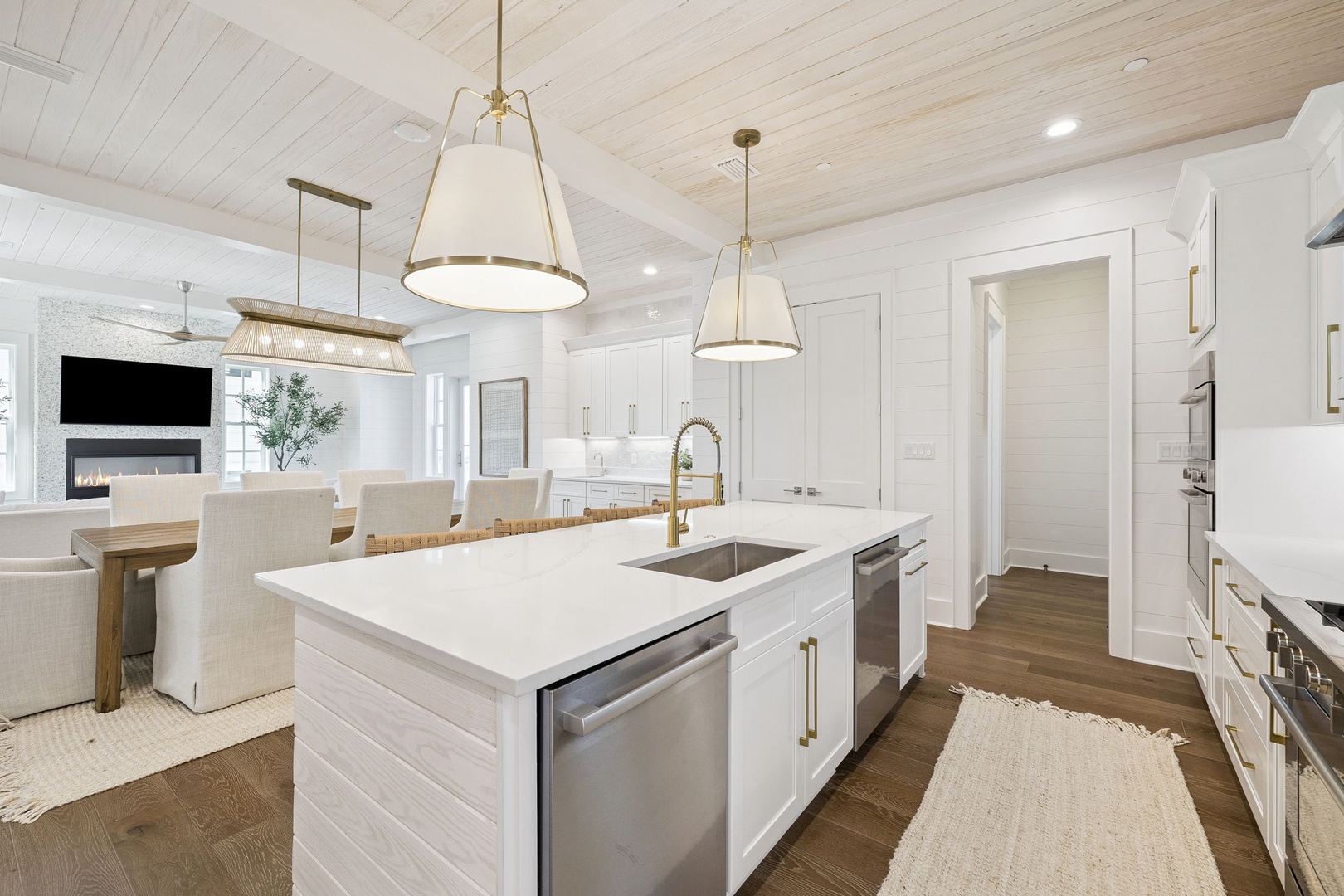 Your gourmet kitchen awaits with pristine white cabinetry, gleaming countertops, and warm brass fixtures creating the perfect space for memorable meals.