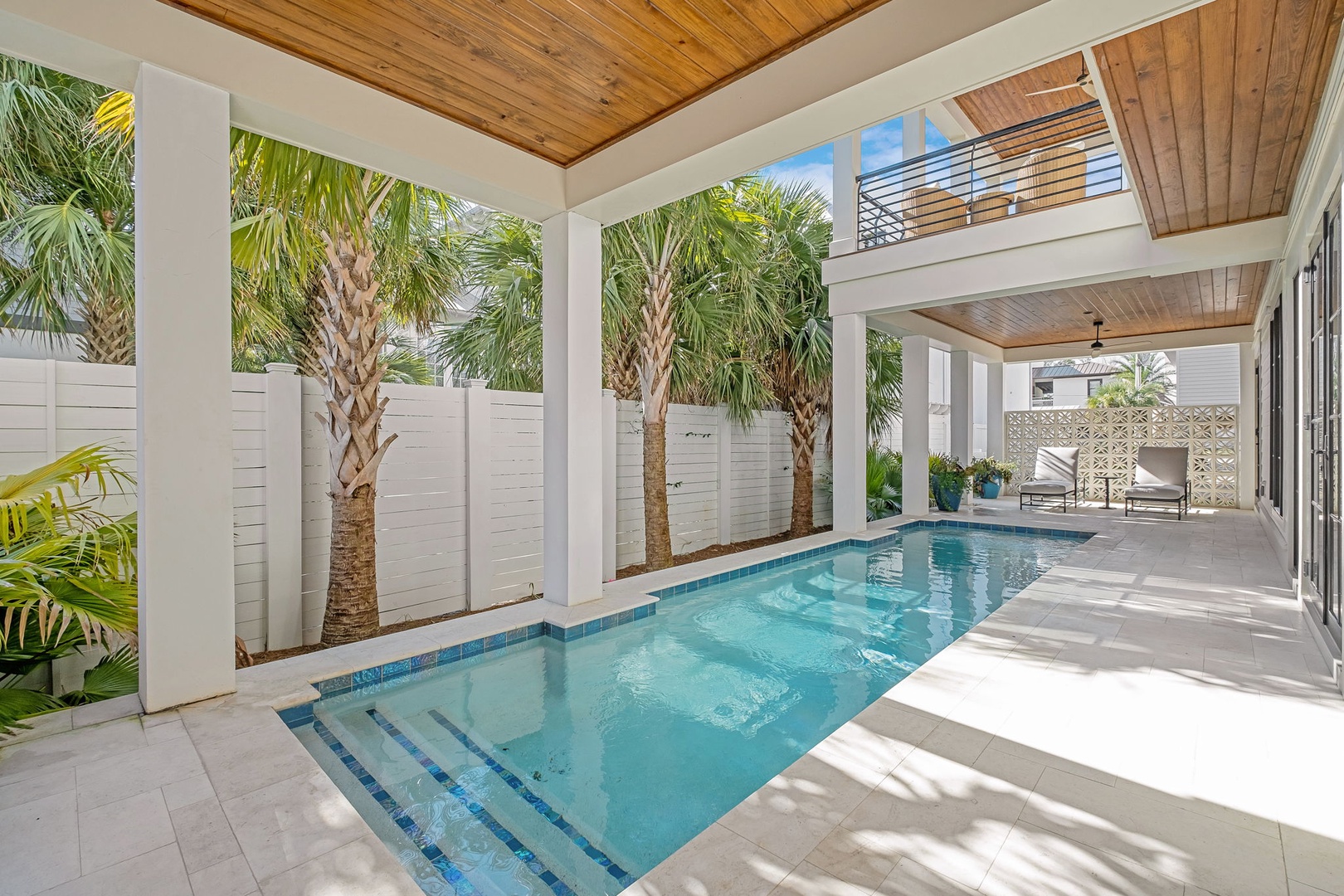 Your private pool paradise awaits under soaring wood ceilings, where tropical palms create a serene backdrop for ultimate relaxation.