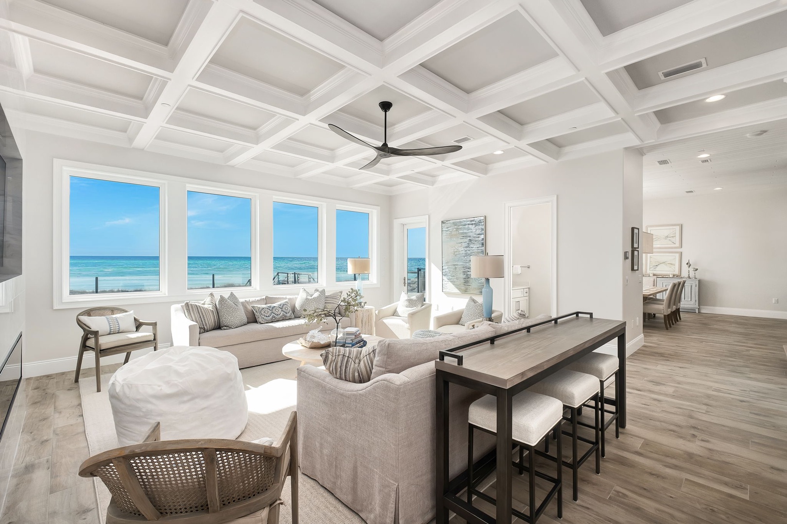 Relax in your stunning oceanfront living room where coffered ceilings and panoramic sea views create the perfect coastal retreat.