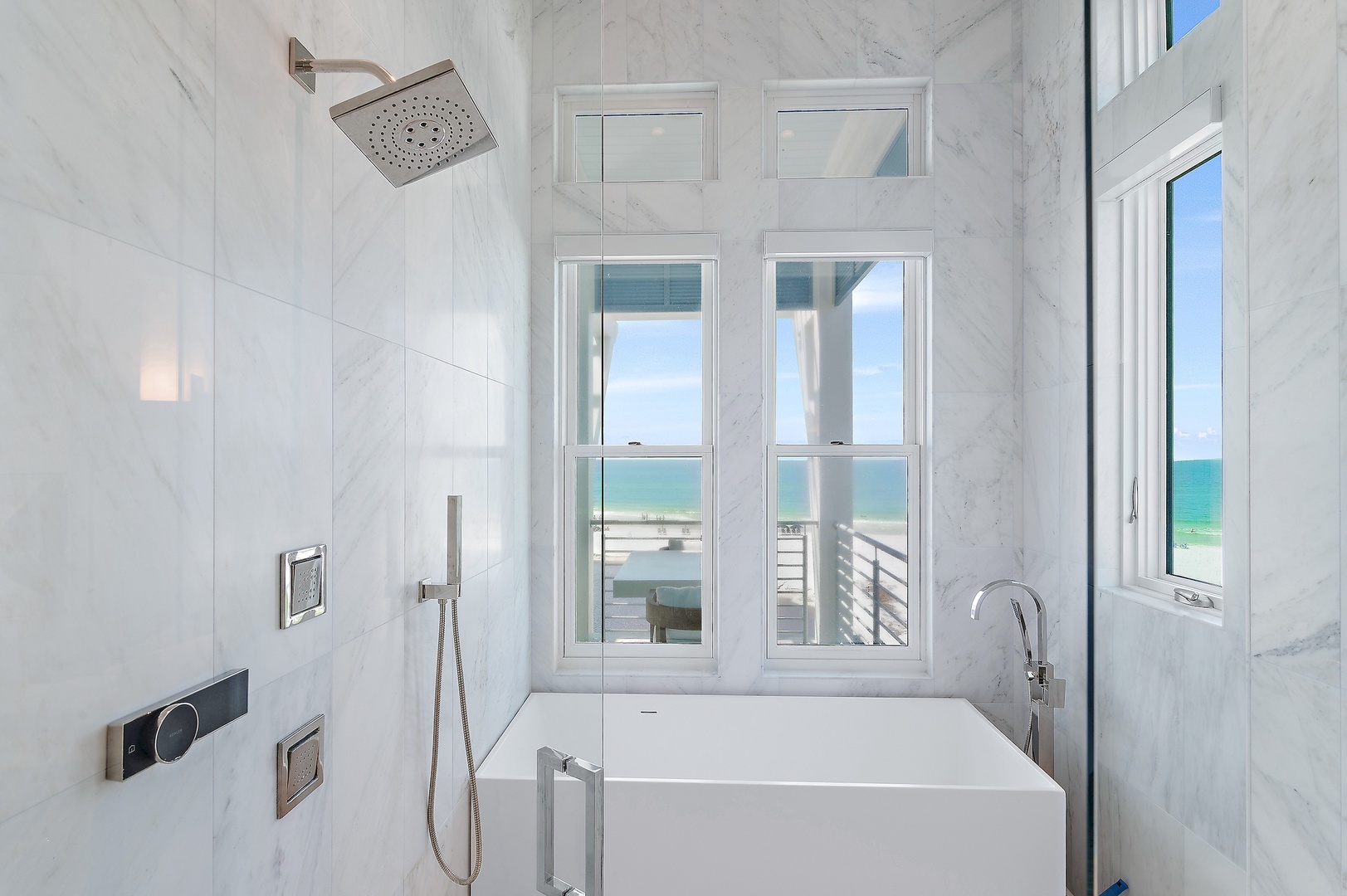Soak away your worries in this elegant freestanding tub, surrounded by pristine marble and stunning views of the turquoise sea stretching beyond your window.