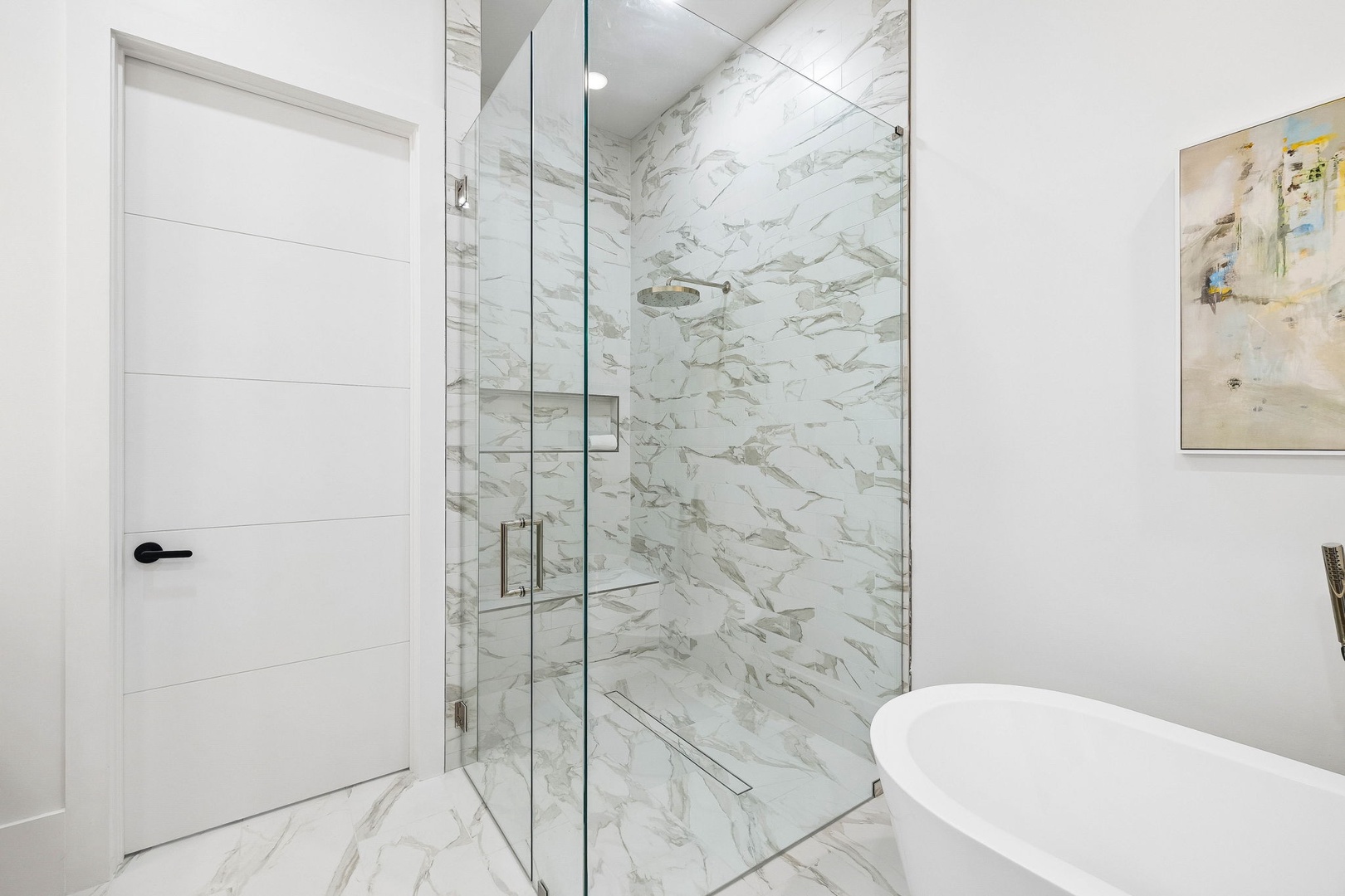 Step into your spa-like marble sanctuary, where a glass-enclosed shower and elegant soaking tub invite you to unwind in pure luxury.