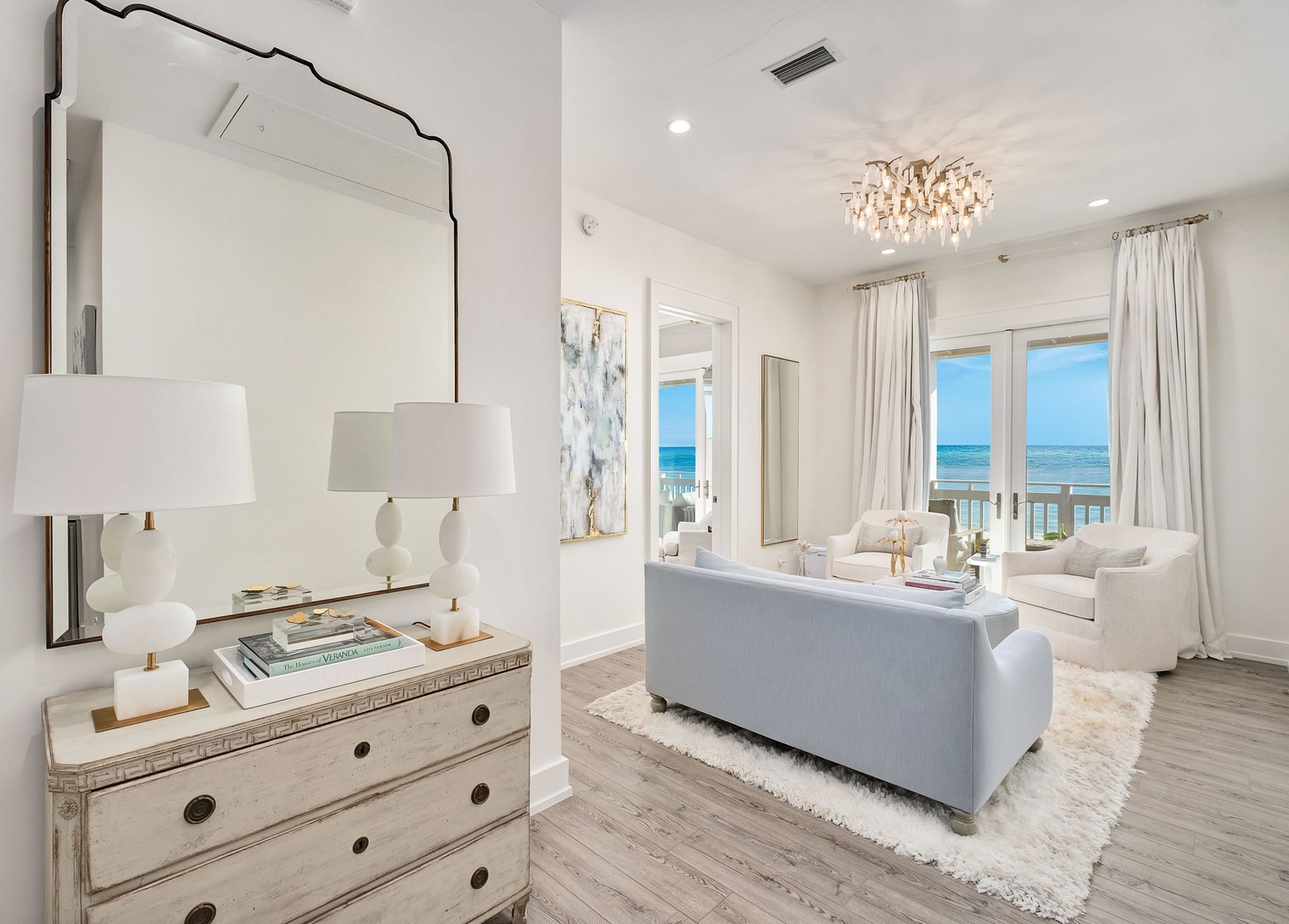 Unwind in your bright, elegant living room where soft coastal hues meet stunning sea views, and every window frames the horizon like living art.